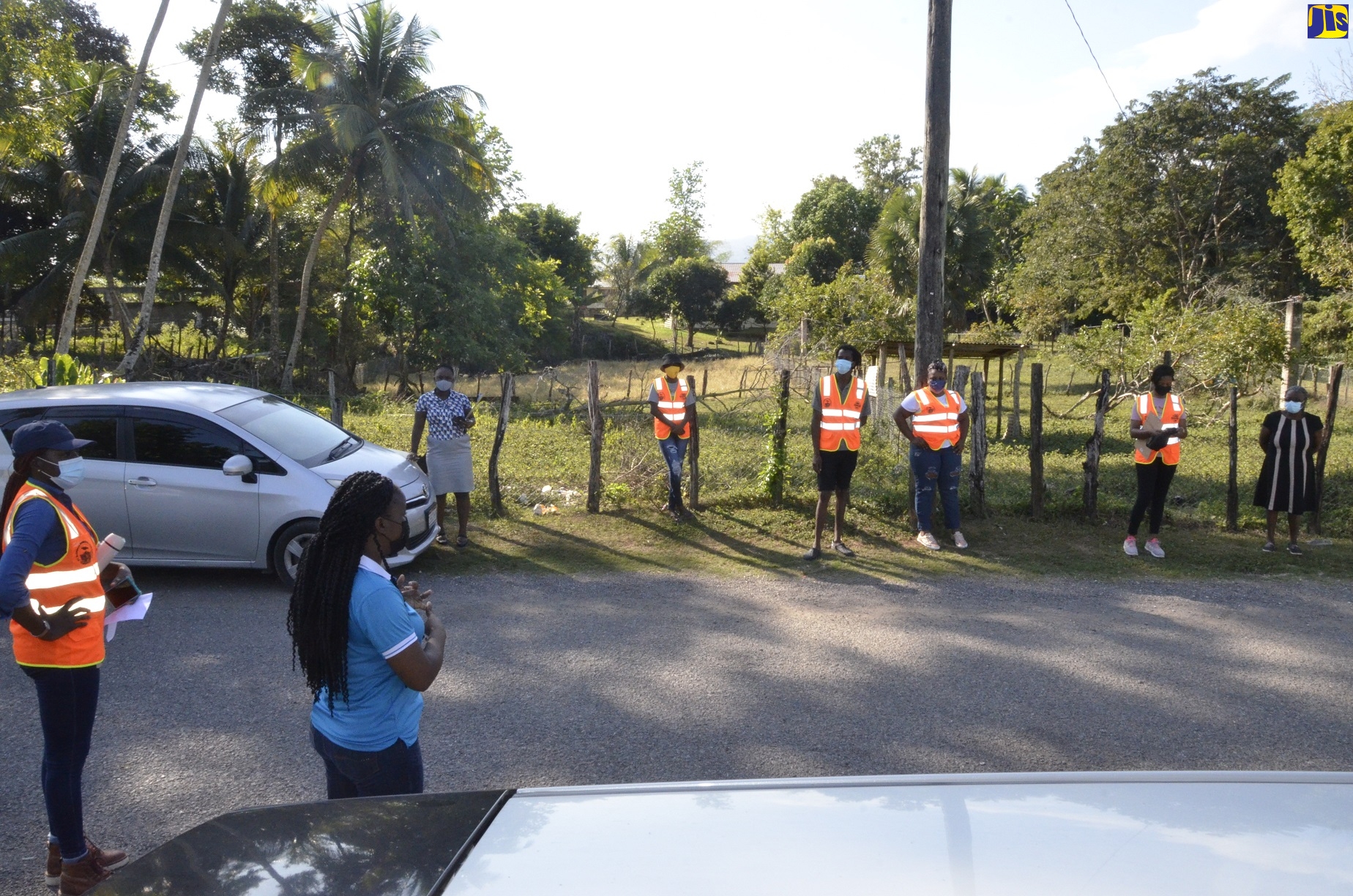 Southern Regional Coordinator for the Office of Disaster Preparedness and Emergency Management (ODPEM), Camille Beckford-Palmer (second left), addresses residents of New River District in St. Elizabeth following a community earthquake and evacuation drill in the area on Tuesday, January 18. Listening keenly is Parish Coordinator for Disaster Preparedness at the St. Elizabeth Municipal Corporation, Ornella Lewis (left).