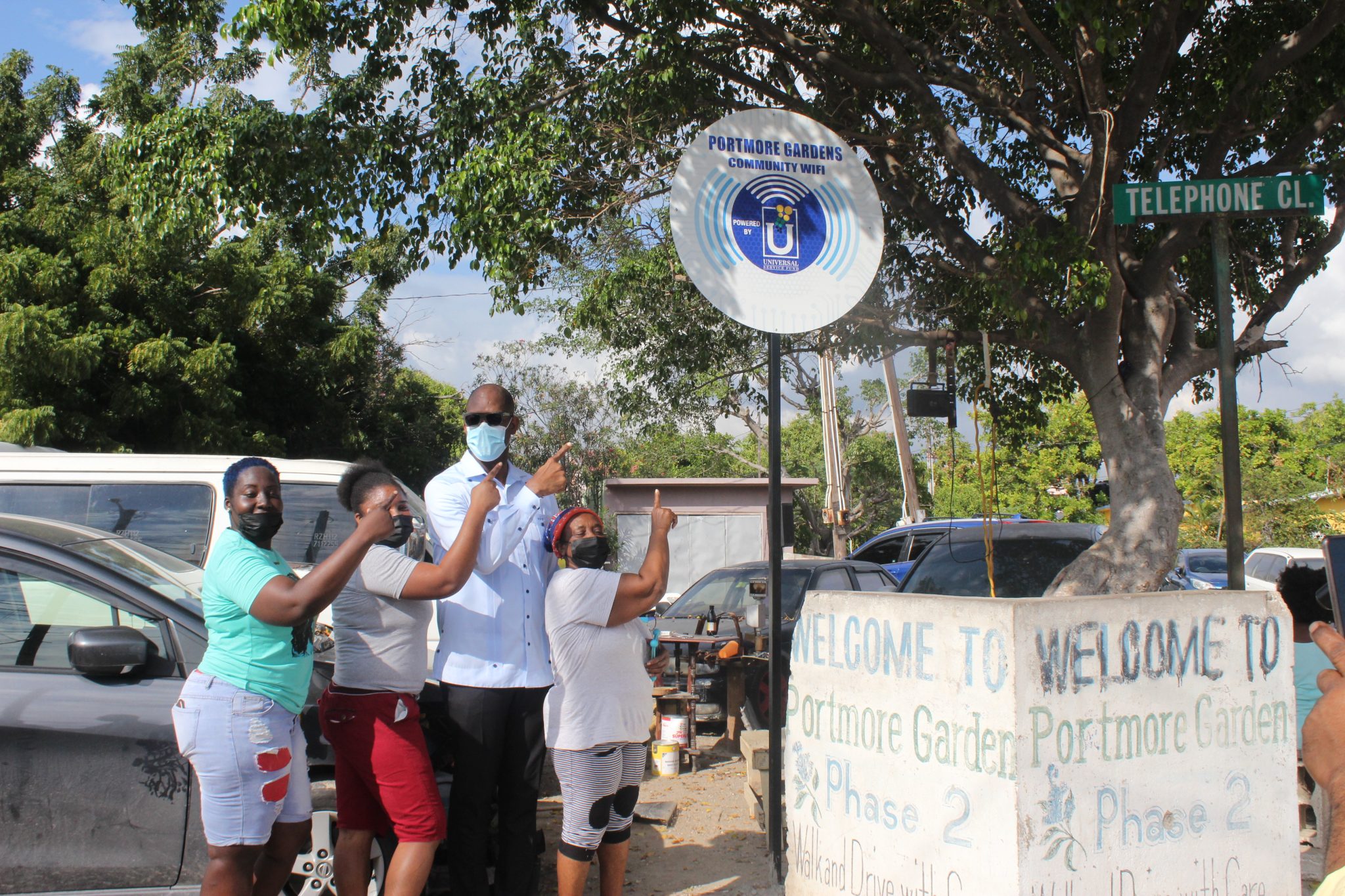 Member of Parliament for St. Catherine South Eastern, Robert Miller (second right), and residents of Portmore Gardens in St. Catherine, point to the free Wi-Fi hotspot sign, following the launch of the service in the community on Monday (January 10). The service was provided by the Universal Service Fund (USF), at a cost of $7.5 million.

