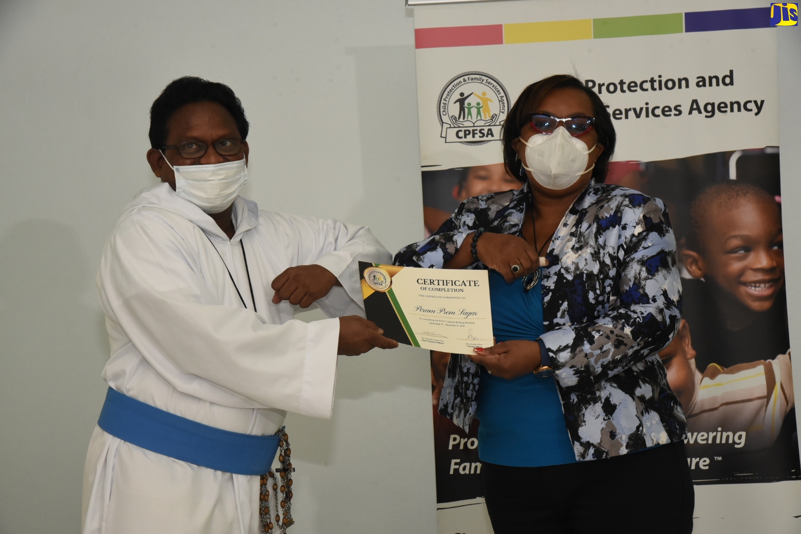 Chief Executive Officer, Child Protection and Family Services Agency (CPFSA), Rosalee Gage-Grey (right), presents a certificate of completion to Peram Prem Sagar from Missionaries of the Poor Bethlehem, for successfully completing a capacity-building workshop organised by the CPFSA, for staff of residential childcare facilities (RCCF).  Occasion was the closing ceremony for the 14-week training session, held on Tuesday (January 11), at the Medallion Hall Hotel in Kingston.