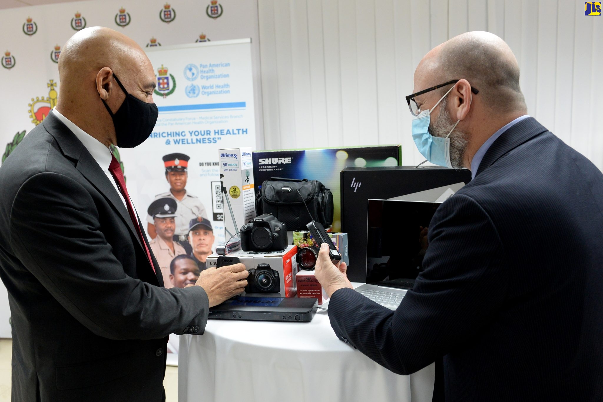 Police Commissioner, Major General Antony Anderson (left), and Pan American Health Organization/World Health Organization (PAHO/WHO) Representative for Jamaica, Bermuda and the Cayman Islands, Ian Stein, examine equipment and software donated to the Jamaica Constabulary Force (JCF) by PAHO. The items were handed over during a ceremony at the Police Commissioner’s office in Kingston on Friday (January 14).