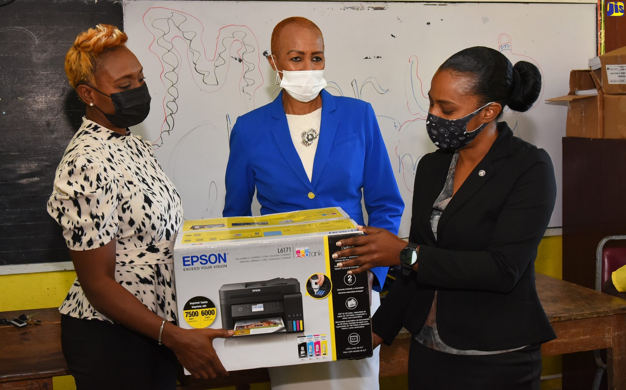 Member of Parliament for St. Andrew West Rural, the Hon. Juliet Cuthbert Flynn (left), and Minister of Education, Youth and Information, the Hon. Fayval Williams (centre), hands over a cartridge-free Epson printer to the Acting Principal of Rock Hall Primary School, Keisha Mehabear, during a visit to the school in rural St. Andrew on Tuesday (January 4). The printer, along with printing paper, was donated by the Usain Bolt Foundation.