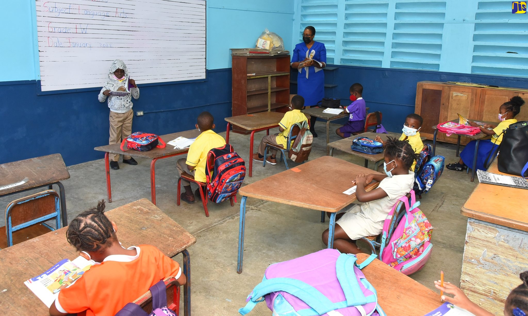 Grade One Teacher at Rock Hall Primary School in St. Andrew, Ms. Sonia Wilks (right), listens as one of her students reads a book at a recent ceremony. 