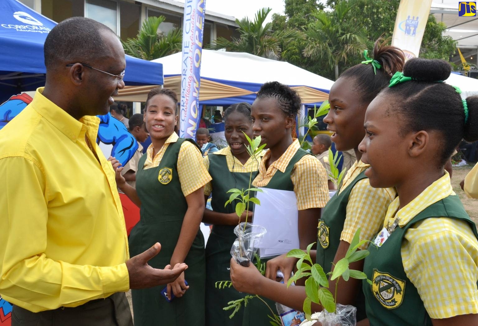 Executive Director of the Jamaica 4-H Clubs, Dr. Ronald Blake (left), conversing with students from the St. Ann-based Ocho Rios High School at the 2016 staging of the National Achievement Expo held at the Denbigh Showground in May Pen, Clarendon.