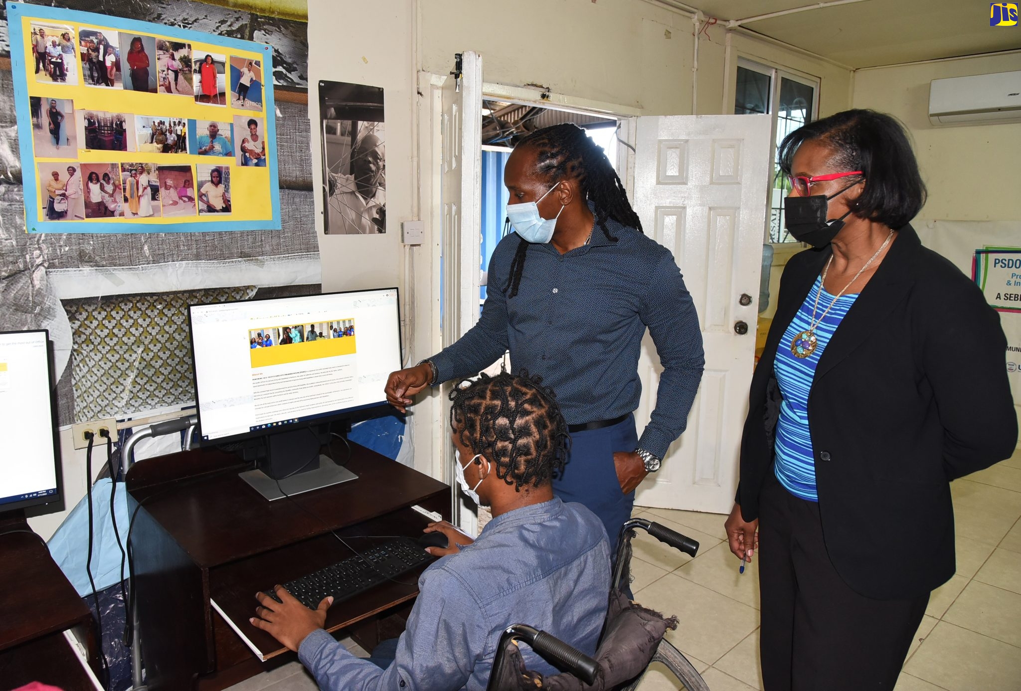 Chief Technical Director in the Ministry of Labour and Social Security, Dione Jennings (right), and Minister of State in the Ministry of Culture, Gender, Entertainment and Sport, Hon. Alando Terrelonge (left), look on as member of the disabled community, Shane Simpson, does research on a computer donated by the Universal Service Fund (USF). Occasion was the launch of the Special Groups Programme by the USF, at the Portmore Self-Help Disability Organisation in Portmore on Friday (February 11).