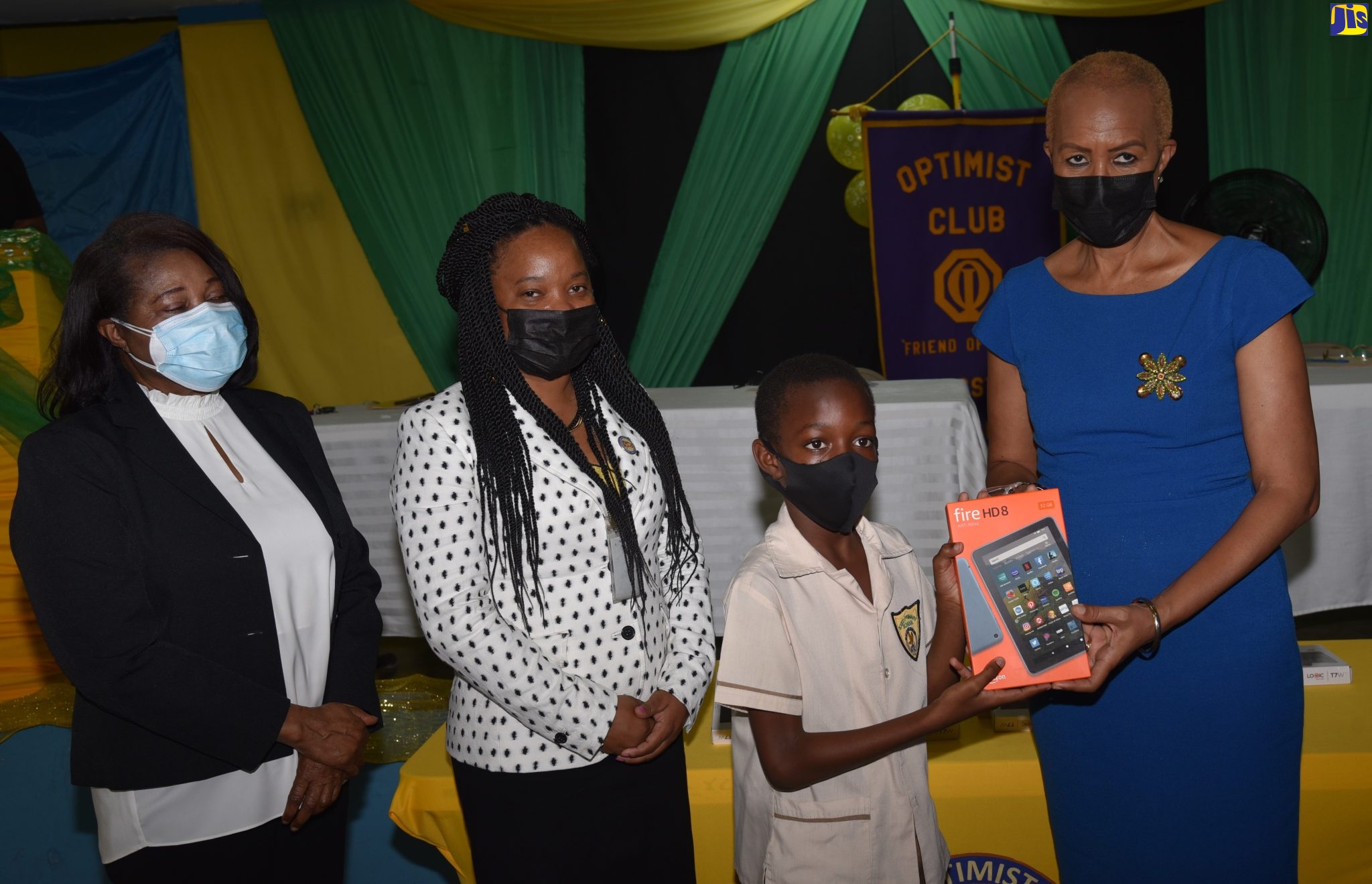 Minister of Education and Youth, Hon. Fayval Williams (right) presents student of Excelsior Primary and Infant School, Kingston, Devaunte Baccas with a tablet during the handover of the devices by the Optimist Club of Kingston on February 3. Sharing in the moment are (from left): patron of Optimist Club of Kingston, Wife of the Governor- General, Her Excellency the Most Hon. Lady Allen; and President of the Optimist Club of Kingston, Aneskia Smalling. The activity is one of several to commemorate International Optimist Day which is celebrated on the first Thursday in February of each year.