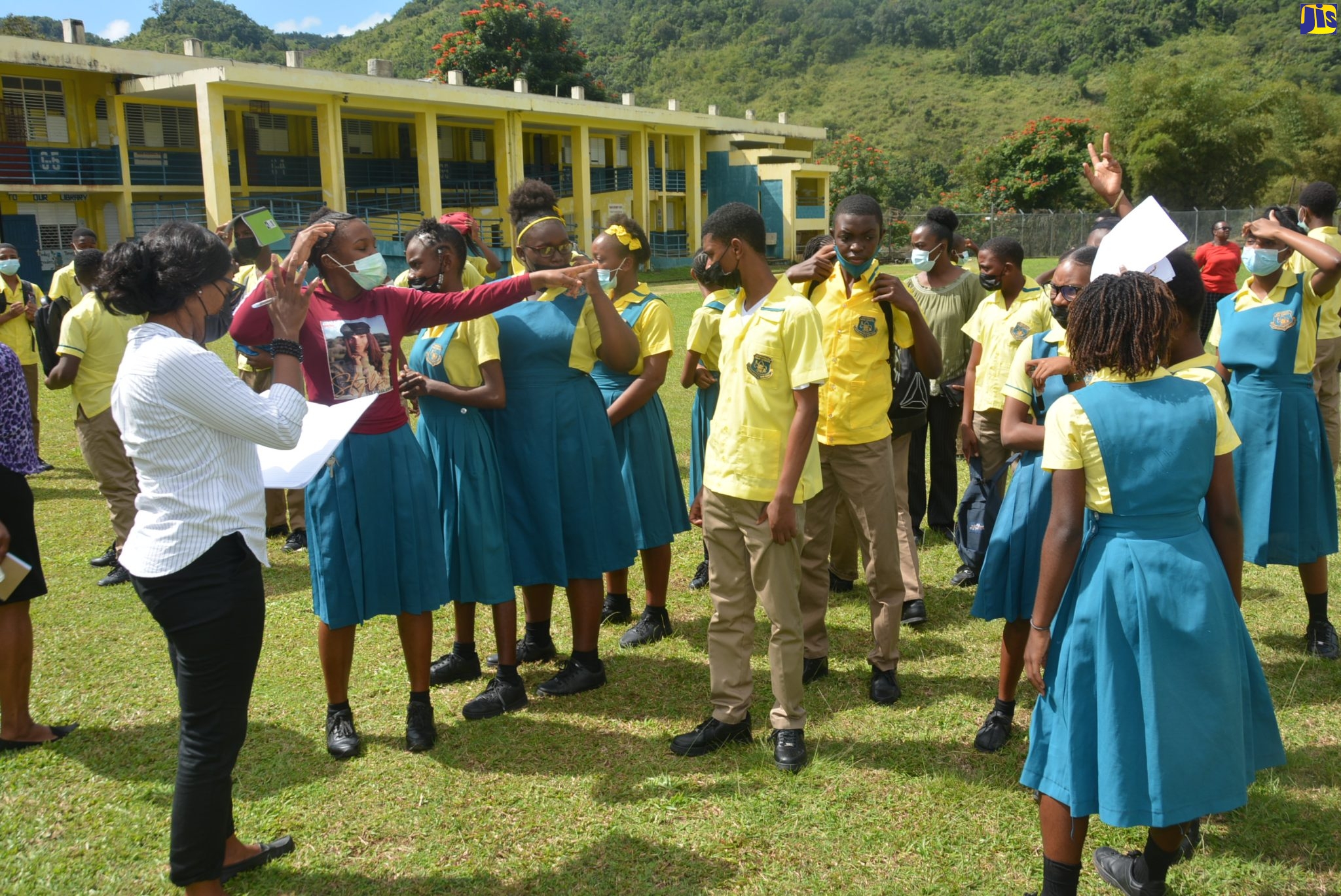 Grade nine teacher of Lewisville High School in St. Elizabeth, Obena Gordon-Atkinson (left), performs a roll call of students following an earthquake and evacuation drill staged at the school recently.