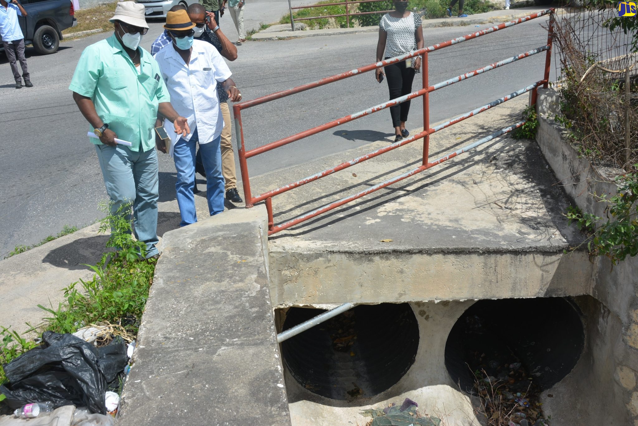 Minister without Portfolio in the Ministry of Economic Growth and Job Creation, Hon. Everald Warmington (second left), and Member of Parliament for St James Central Heroy Clarke (left), examine a drain in Green Pond, St. James, during a tour on Tuesday (February 22).
