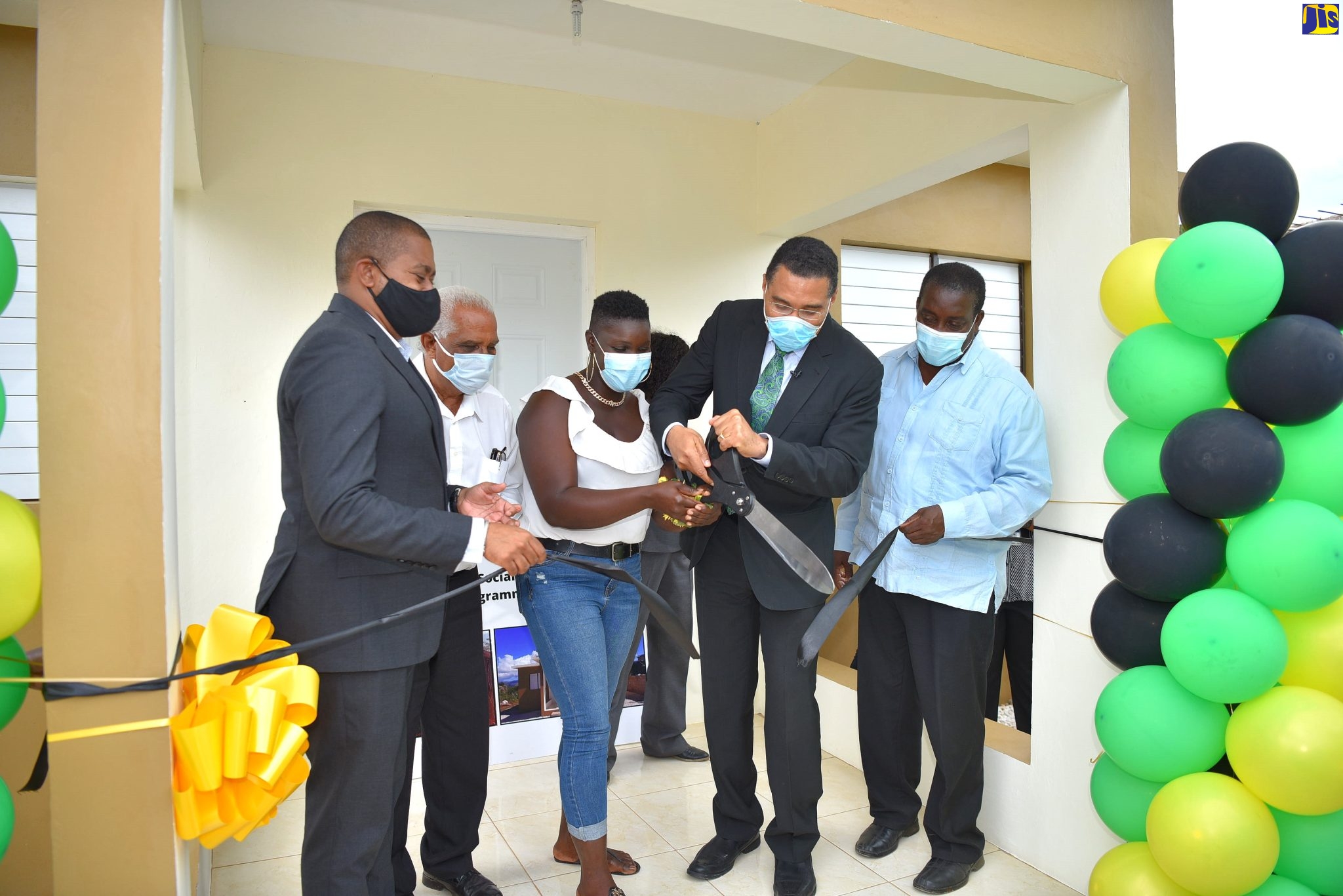 Prime Minister, the Most Hon. Andrew Holness (fourth left), cuts the ribbon to officially hand over a social housing unit in Flagaman, St. Elizabeth, after a ceremony held on Wednesday (February 23). Sharing the occasion are (from left) Minister without Portfolio in the Office of the Prime Minister and Member of Parliament for St. Elizabeth Southwestern, Hon. Floyd Green; Councillor for the Pedro Plains Division, Jeremy Palmer; recipient of the housing unit , Shelly-Ann Russell, and Minister without Portfolio in the Ministry of Economic Growth and Job Creation, Hon. Robert Montague. 

