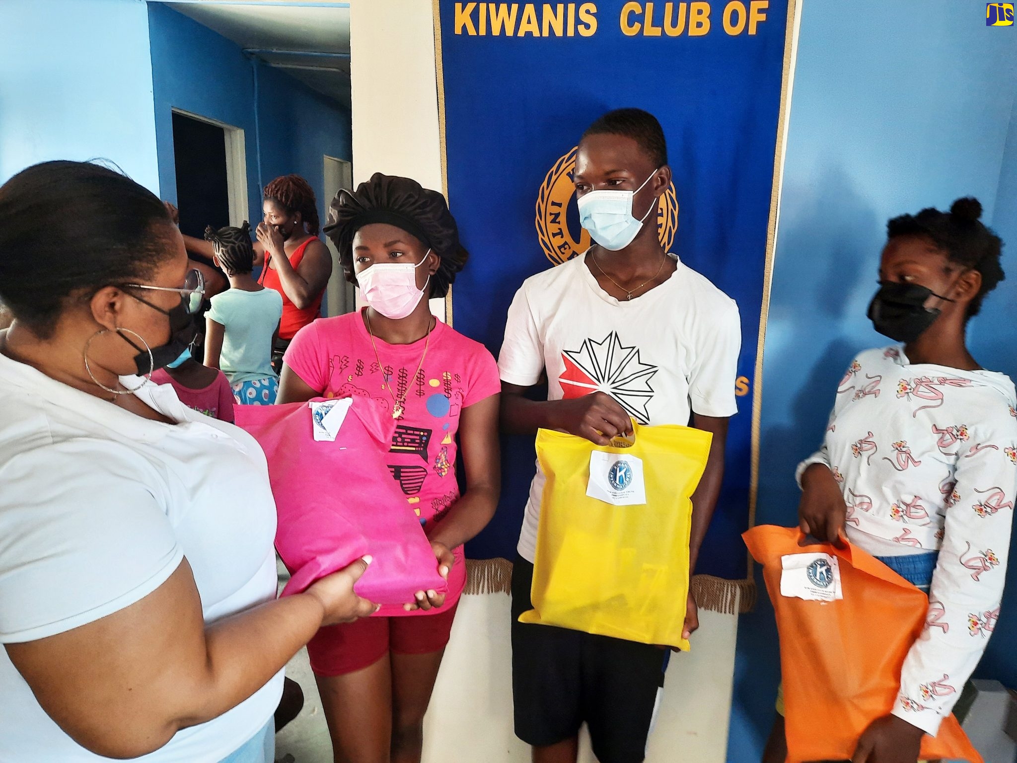 President of the Kiwanis Club of Young Professionals – St. Catherine, Rhamona Bromfield (left),  presents packages containing school supplies and food items to Jonathan Grant High School student, Shennel Pinnock (second left), at the Clifton Basic School in St. Catherine, recently. Travorne Rodgers of Ascot High and Nicola Levy of Ascot Primary look on.