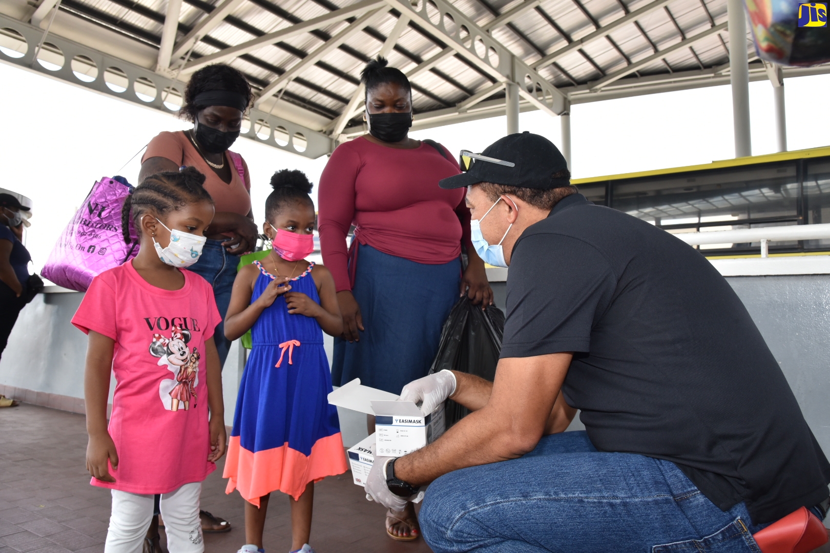 Minister of Health and Wellness, Hon. Dr. Christopher Tufton, engages with these little girls, during the distribution of masks to members of the public in Half-Way-Tree, St. Andrew on Saturday (Feb.12). The exercise was part of continued measures by the Ministry to contain the spread of the coronavirus (COVID-19) and encourage citizens to protect themselves.