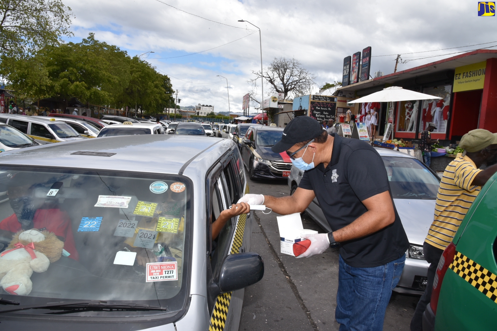Minister of Health and Wellness, Hon. Dr. Christopher Tufton hands out masks to passengers in a taxi, during a distribution exercise in Half-Way-Tree, St. Andrew on Saturday (Feb.12). The distribution of masks is part of continued measures by the Ministry to contain the spread of the coronavirus (COVID-19) and encourage citizens to protect themselves.