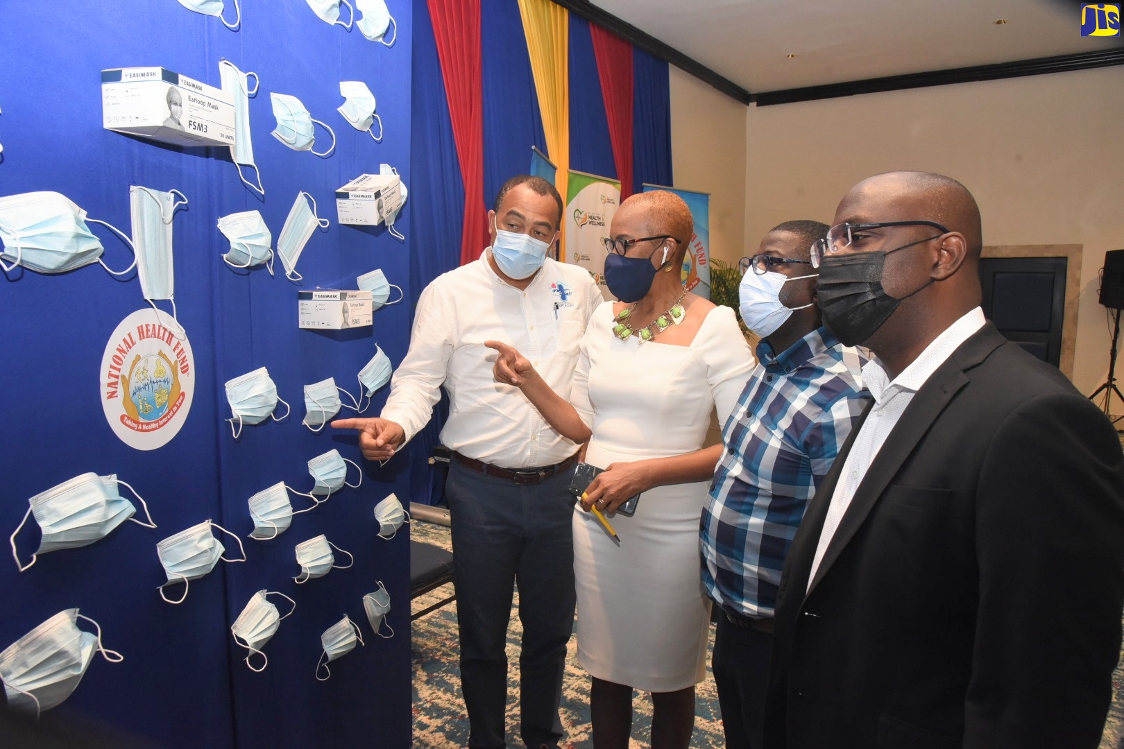Minister of Health and Wellness, Dr. the Hon. Christopher Tufton (left), and Minister of Education and Youth, the Hon. Fayval Williams, look at a display of disposable face masks. They are joined by Chief Executive Officer, National Health Fund (NHF),  Everton Anderson (second right), and Acting Board Chairman, NHF,  Shane Dalling. Occasion was the handover of two million masks by the Health Ministry to benefits schools, frontline personnel, community responders and vulnerable groups,  at the Pegasus Hotel in Kingston on Friday (February 11).