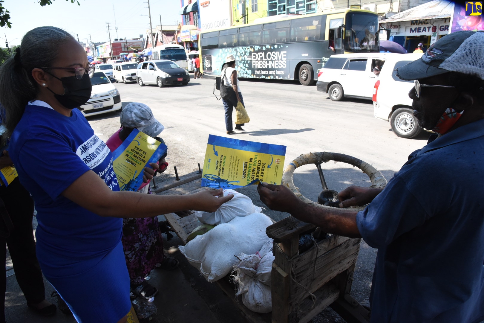 : Permanent Secretary in the Ministry of Labour and Social Security, Colette Roberts-Risden (left) hands a flyer to a vendor in downtown Kingston on February 14 as part of measures to generate awareness among citizens about the Disabilities Act. The legislation, which promotes and protects the rights of persons with disabilities, came into full effect on Monday, February 14, 2022.