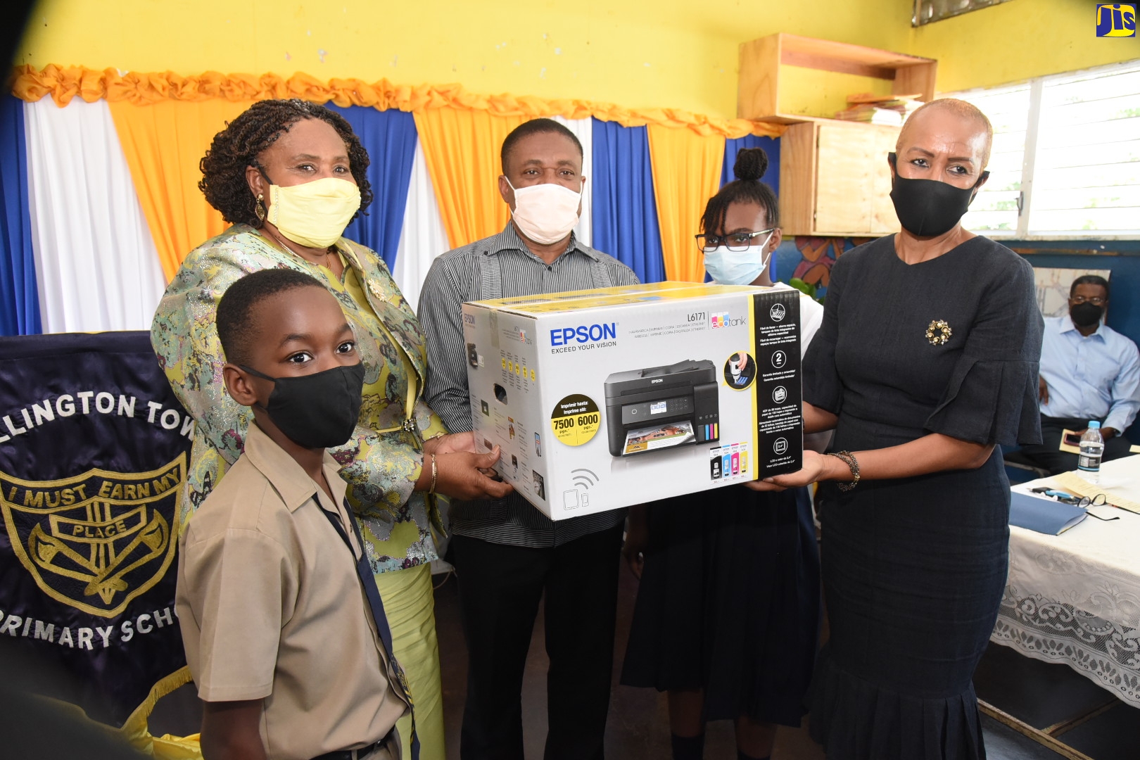 Minister of Education and Youth, Hon. Fayval Williams (right), and Member of Parliament for Kingston East and Port Royal, Phillip Paulwell (centre), hand over an Epson printer, donated by the Usain Bolt Foundation to the Rollington Town Primary School in Kingston on Tuesday (February 15). Receiving the printer on behalf of the school is Principal, Dr. Margaret Bailey (second left) and students, Roy-Jay Francis (left) and Jellicia McLennon. 

