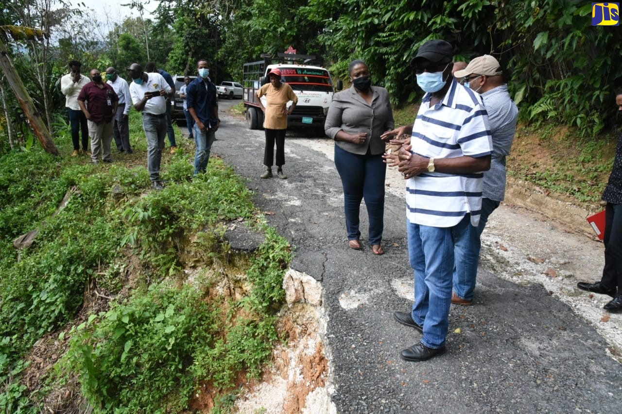 Minister without Portfolio in the Ministry of Economic Growth and Job Creation, Hon. Everald Warmington (right), inspects a damaged road in St. Catherine North East, during a recent tour. At left is the Member of Parliament for the area, Kerensia Morrison.