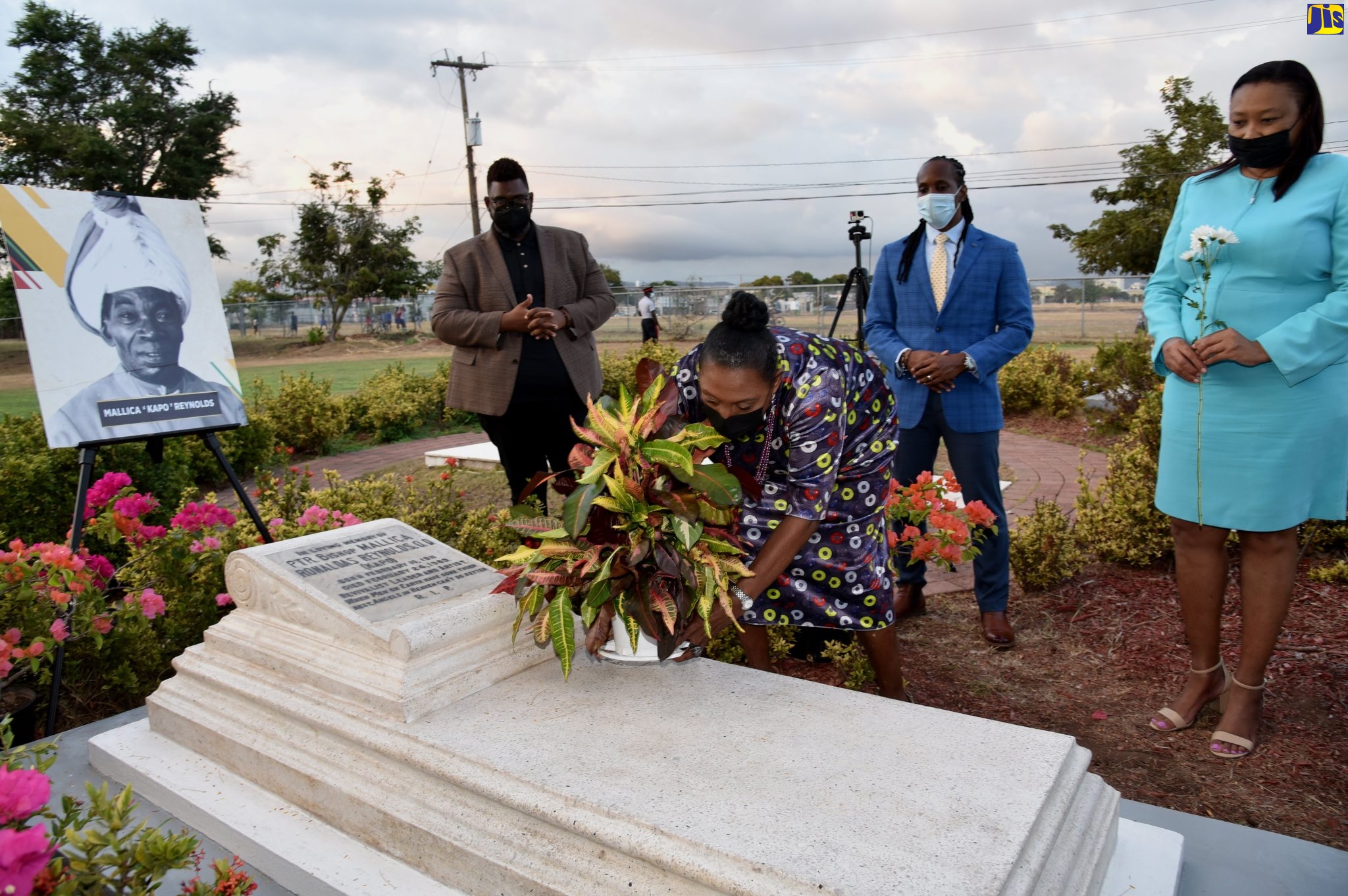 Culture, Gender, Entertainment and Sport Minister, Hon. Olivia Grange (second left), places a potted plant on the grave of  the late Jamaican artist and religious leader, Mallica “Kapo” Reynolds, to commemorate the anniversary of his birth on February 10, 1911. He died February 24, 1989. The ceremony was held at the National Heroes Park on February 10.  Looking on are (from left) Director of Events Management Production, Jamaica Cultural Development Commission (JCDC), Gregory Simms; State Minister in the Ministry, Hon. Alando Terrelonge; and Acting Executive Director,  JCDC, Lillian Reid. One of his paintings, ‘Shining Spring’, was selected by the Jamaican Government as a wedding gift for the 1981 wedding of Prince Charles and Lady Diana (now deceased).