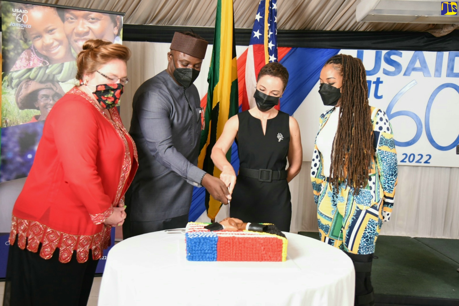 Foreign Affairs and Foreign Trade Minister, Senator the Hon. Kamina Johnson Smith (centre) is assisted by Acting Deputy Chief of Mission U.S. Embassy, Michelle Mason (left) and Country Manager, USAID, Jason Fraser in cutting a cake as part of commemorative activities marking the 60th anniversary of partnership between the Government of Jamaica and the United States Agency for International Development (USAID). This milestone was celebrated with a reception on Thursday (March 24) at the Terra Nova All-Suite Hotel, St. Andrew