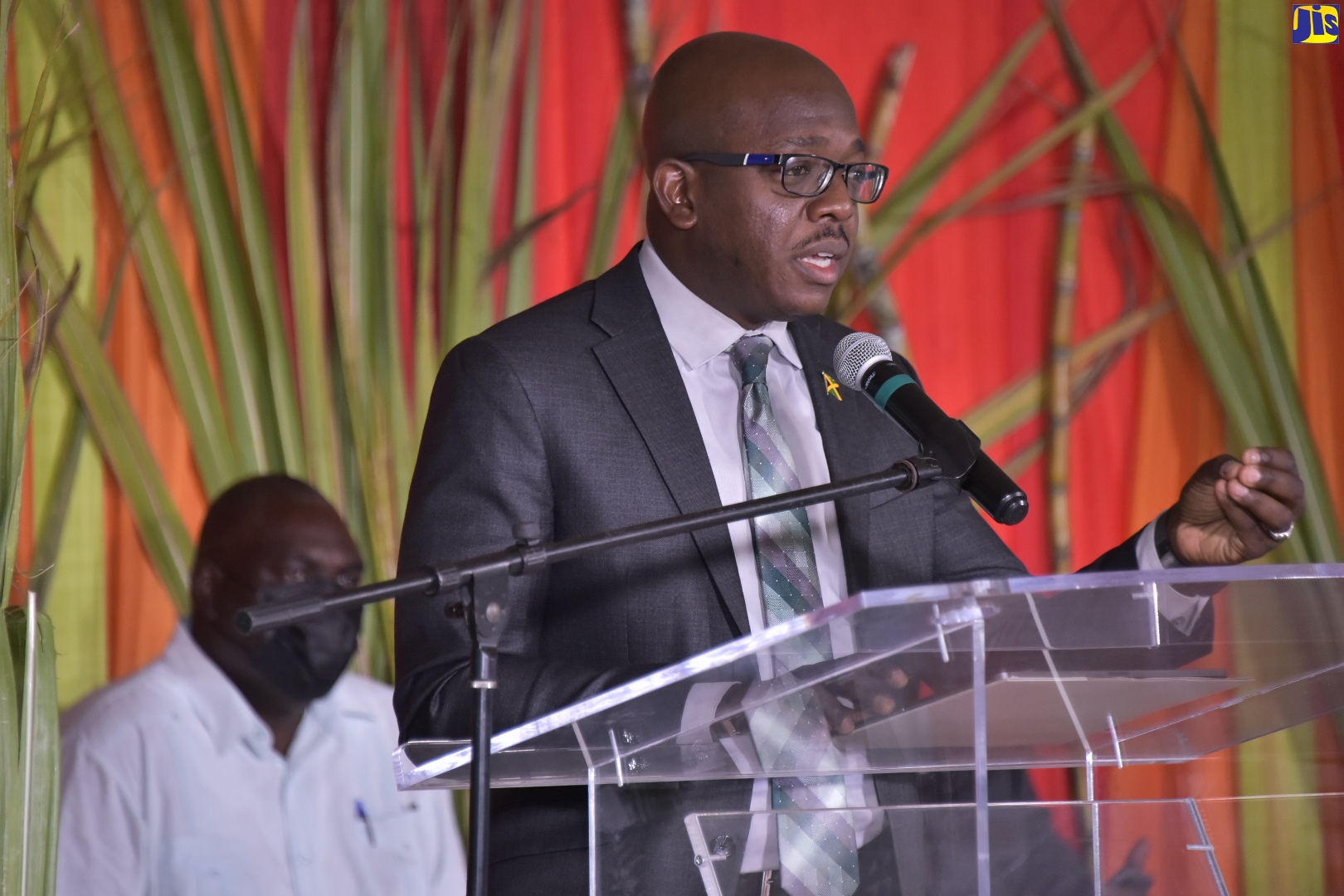 Minister of Agriculture and Fisheries,  Hon. Pearnel Charles Jr., speaks at the launch of the book, ‘How Trade Liberalisation Affects a Sugar-Dependent Community in Jamaica’, at the University of the West Indies, Mona Campus, on March 16.  Seated at left is the author, Registrar at the University of the West Indies (UWI), Mona Campus, Dr. Donovan Stanberry.