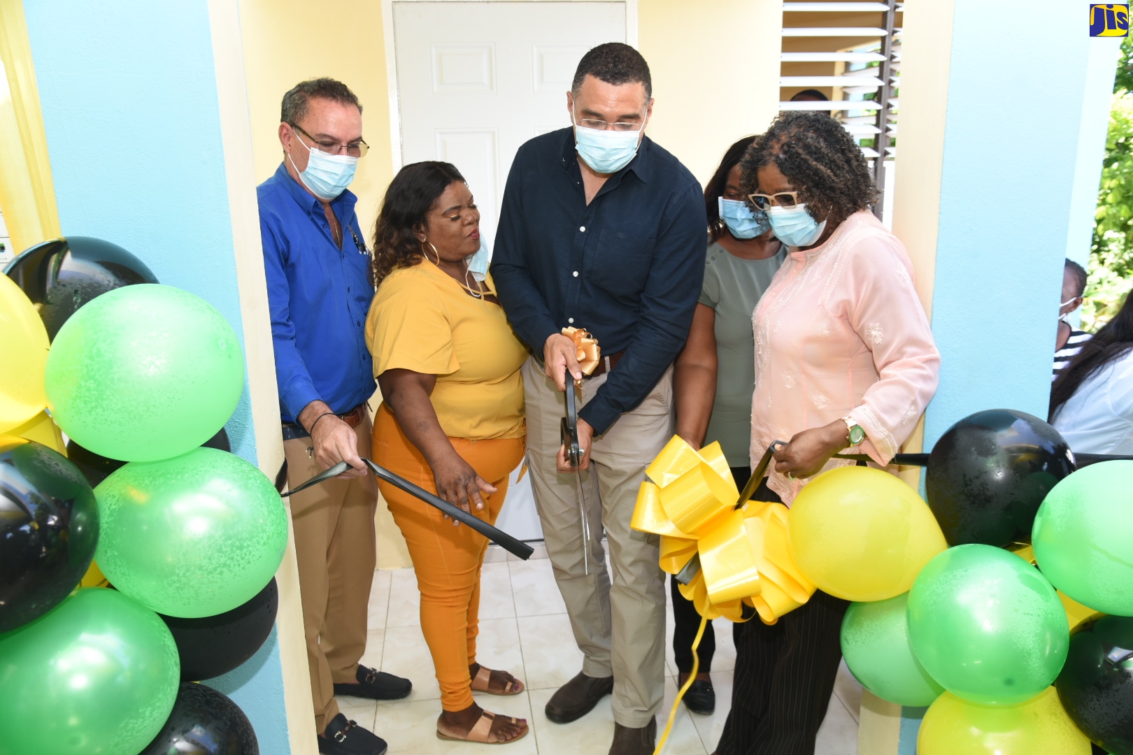 Prime Minister, the Most Hon. Andrew Holness (centre), cuts the ribbon at the handing over of a three-bedroom unit under the Government New Social Housing Programme (NSHP), in Orange Bay, Portland, on Friday (March 25). Others pictured from left are: Member of Parliament for Portland West, Hon. Daryl Vaz, recipient, Clovett James, Councillor for the Buff Bay Division, Dionne Hunter, and Permanent Secretary in the Office of the Prime Minister (OPM), Audrey Sewell.