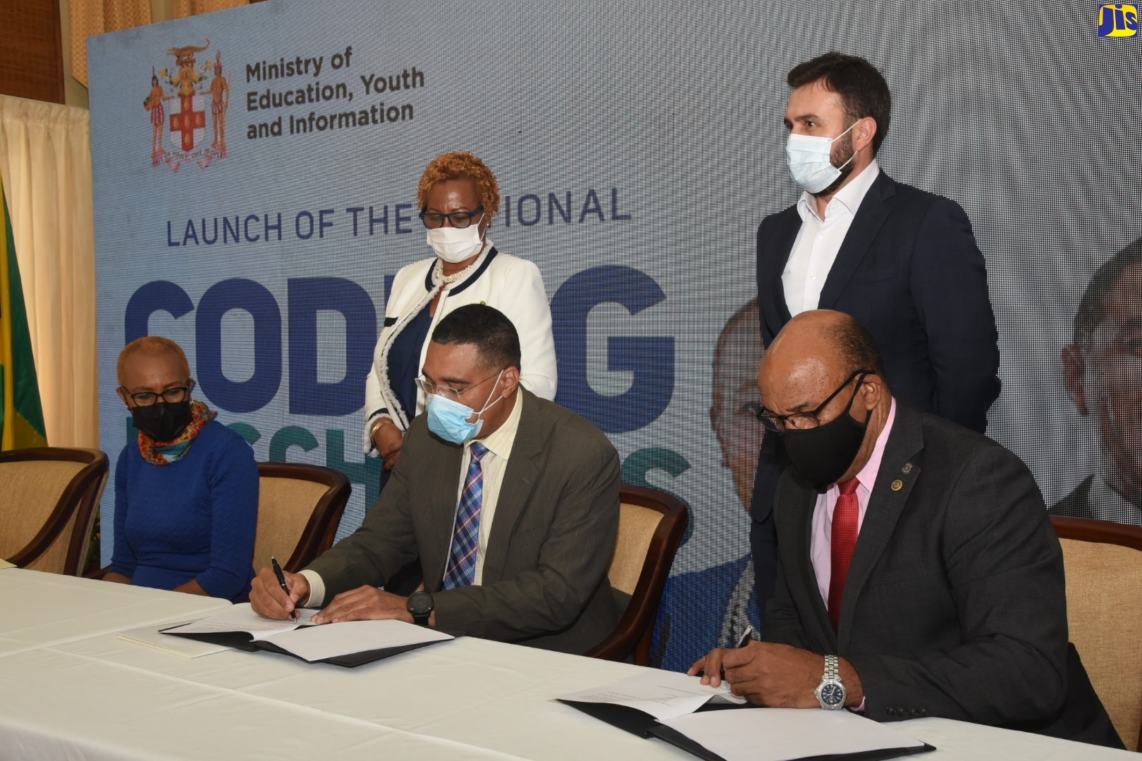 Prime Minister, the Most Hon. Andrew Holness (seated, centre), and Managing Director, Amber Group, Michael McNaughton (seated, right), affix their signatures to copies of a Memorandum of Understanding (MOU) to facilitate the implementation of the National Coding in Schools Programme, during a virtual ceremony last November. Waiting to sign the document is Minister of Education, Youth and Information, Hon. Fayval Williams (seated, left). Observing (standing, from left), are Acting Permanent Secretary in the Education Ministry, Maureen Dwyer; and Chief Executive Officer (CEO), Digicel Jamaica, Jabbor Kayumov.

