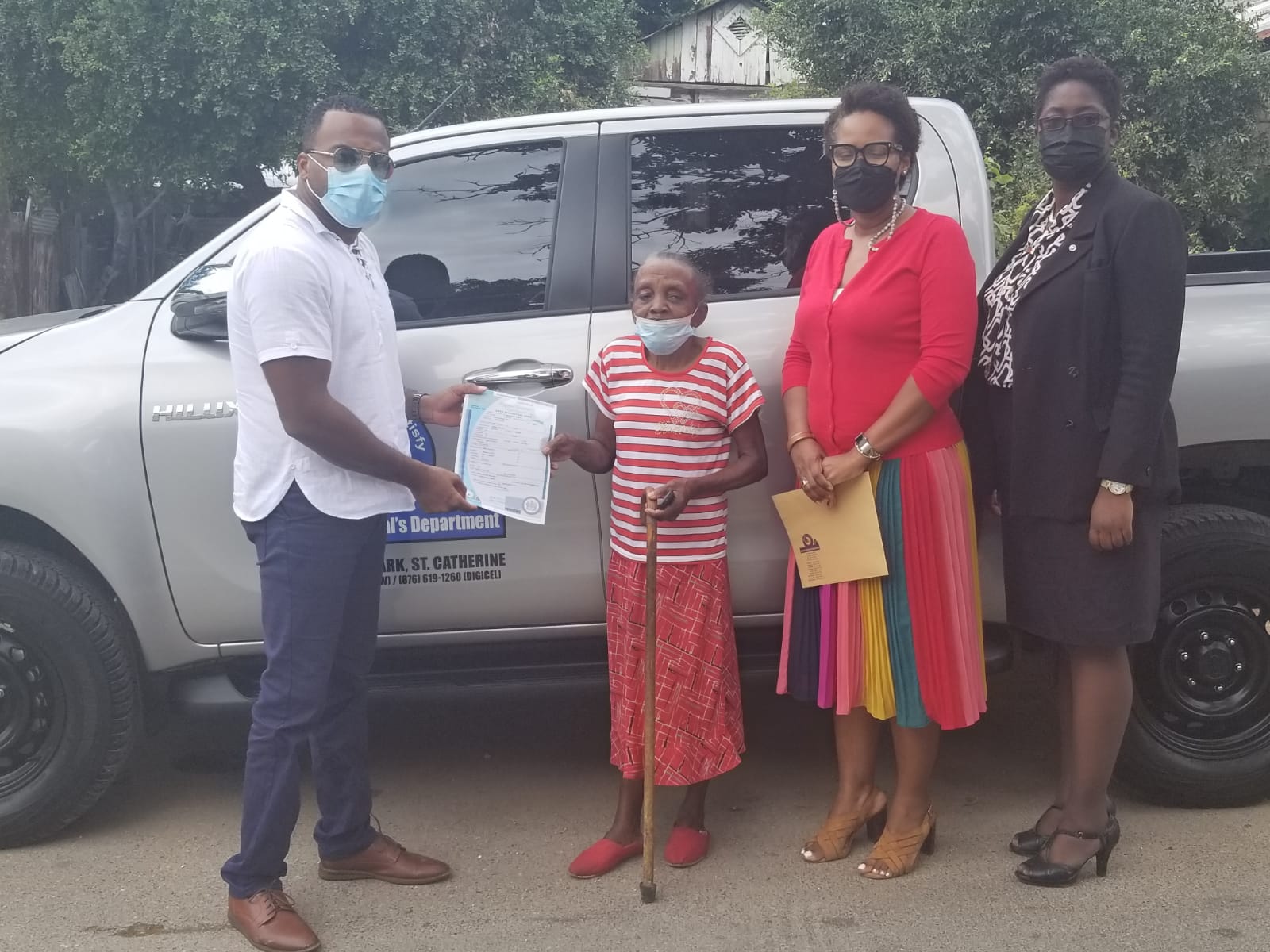 Chief Executive Officer at the Registrar General’s Department (RGD), Charlton McFarlane (left) presents Barbara Phillips with a copy of her birth certificate on Wednesday (March 16). Mr. McFarlane visited her Maxfield Avenue home to personally hand over the document. Deputy CEO, Tameka Clough (third left), and Customer Service Manager (Ag), Kerene Blake-Brown (right), also shared in the occasion.