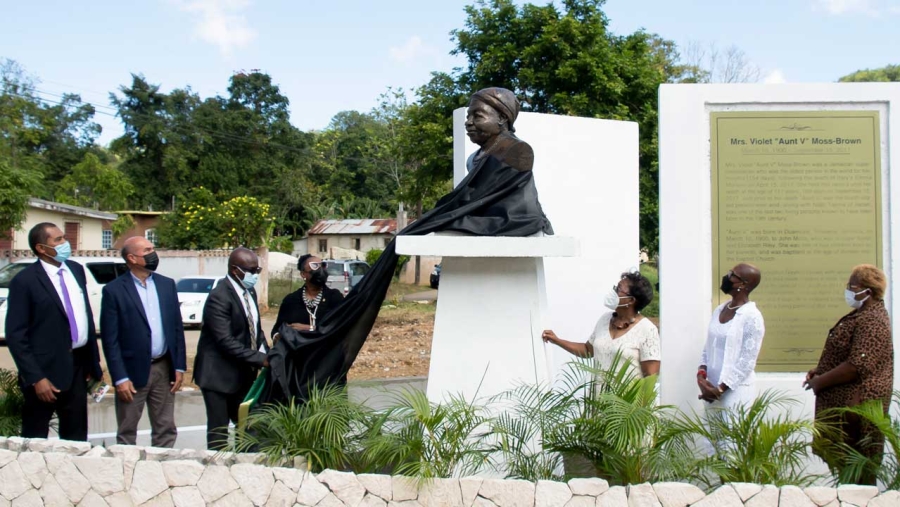 Minister of Culture, Gender, Entertainment and Sport, Hon. Olivia Grange (fourth left), is assisted by Chairman of the Trelawny Municipal Corporation and Mayor of Falmouth, Councillor Colin Gager, in unveiling the monument in honour of supercentenarian Violet Mosse Brown in Duanvale, Trelawny, on March 10. Sharing the moment are (L-R) Councillor for the Sherwood Content Division, Dunstan Harper; Custos of Trelawny, Hugh Gentles; Sculptor, Pamrie Hall Dwyer; and granddaughters of Mrs. Mosse Brown, Dr. Beverly Davis Fray and Lelieth Palmer.  