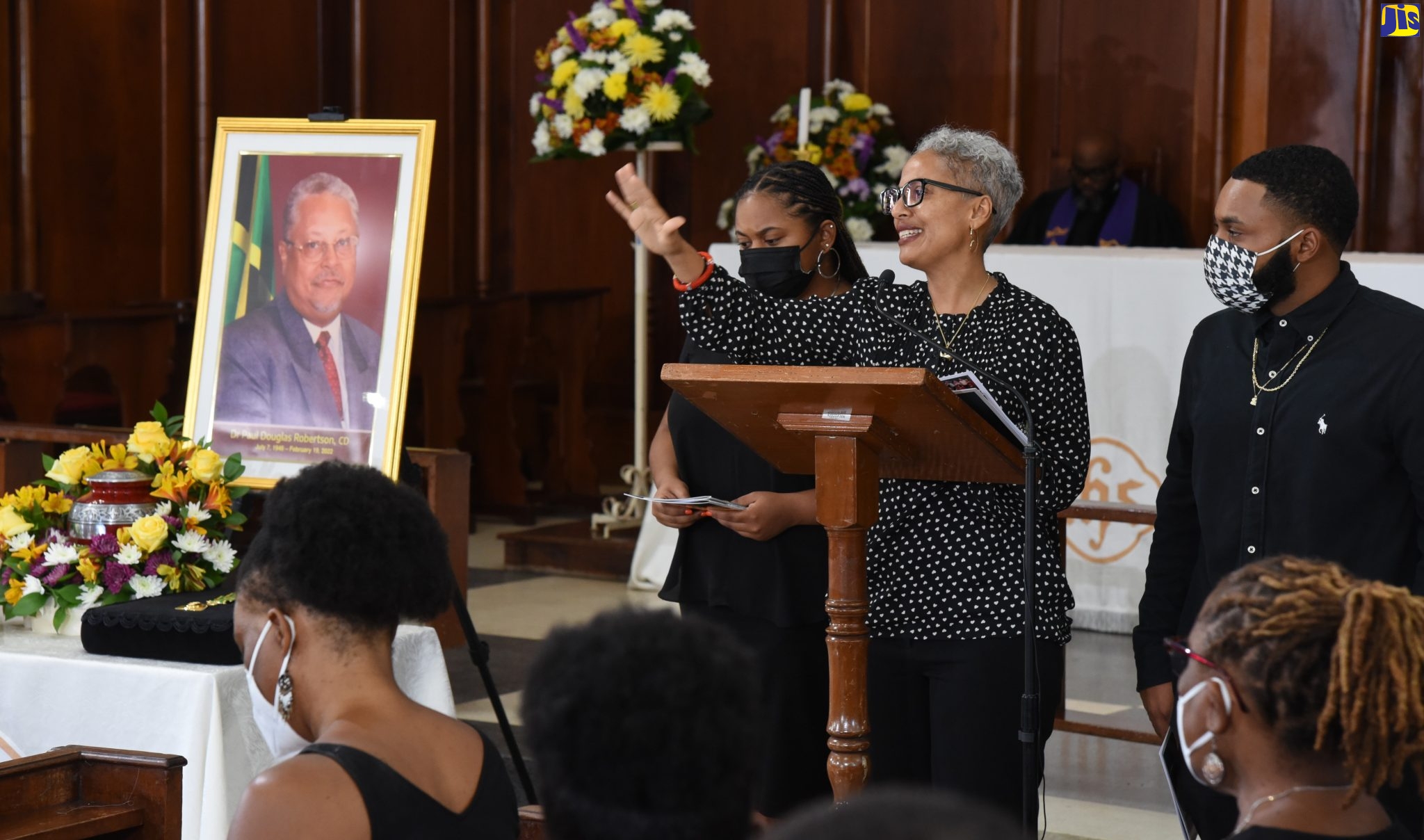 Daughter of the late Parliamentarian and Cabinet Minister, Dr. Paul Robertson, Damali Robertson (centre), pays tribute to her father at the official funeral held on Saturday (March 12), at the University Chapel in Mona, St. Andrew. Also pictured are granddaughter, Nilaja Robertson Thompson (left), and grandson, Osaze Robertson Stewart (right).

