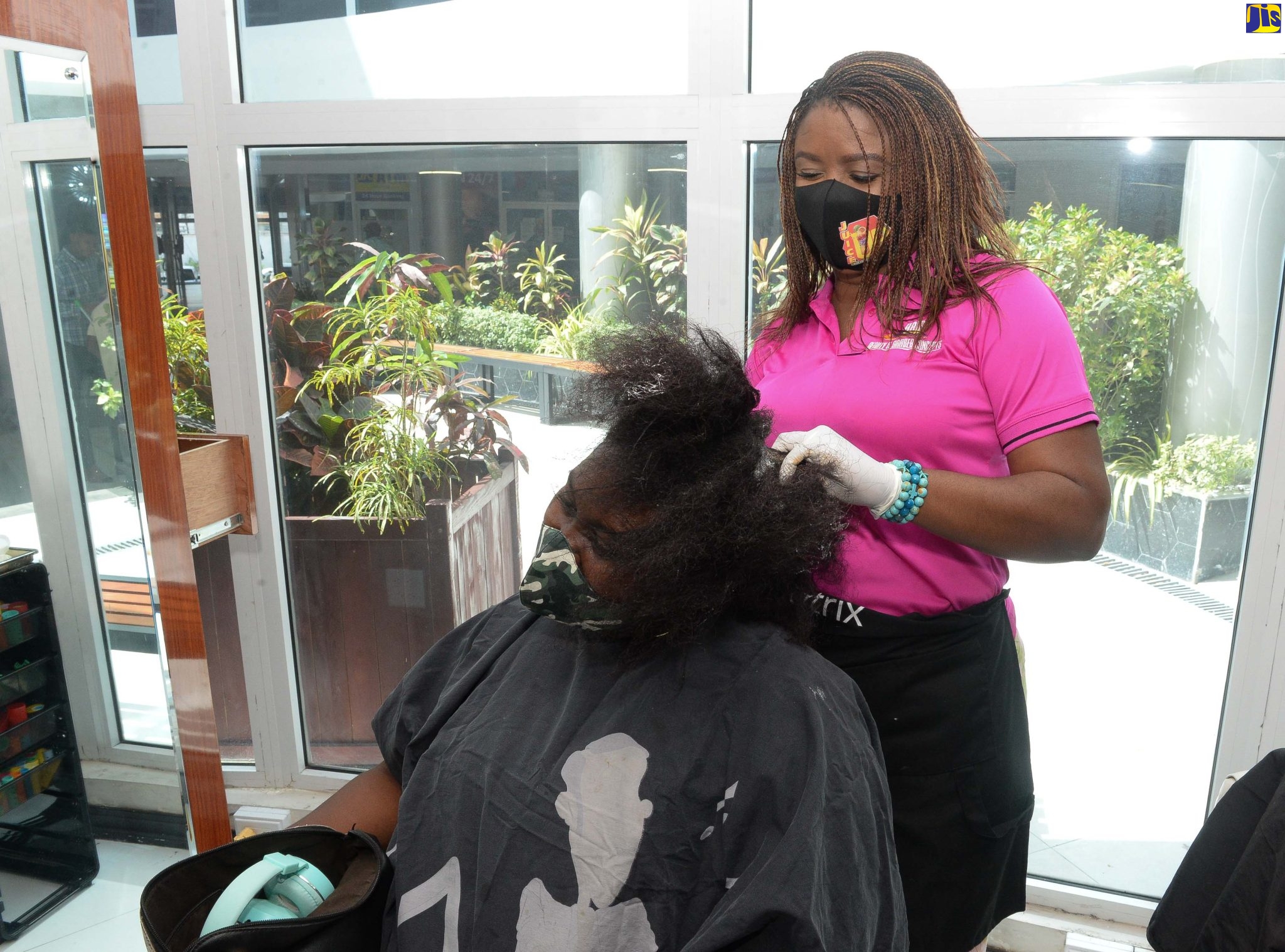 Former adolescent mother, Andreen  Rose-Cephas (right), shampooing a client’s hair at her hairdressing salon in New Kingston.