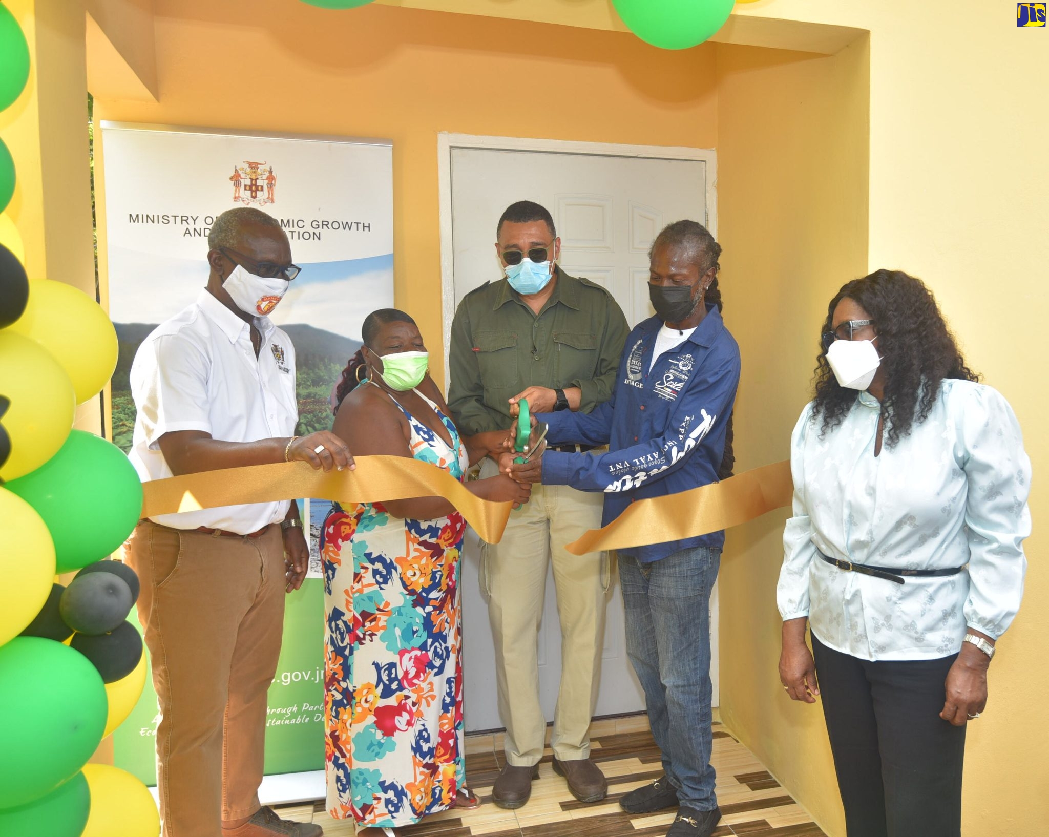 Prime Minister, the Most Hon. Andrew Holness (centre), joins couple Evadane Smith (second left), and Dave Coburn (second right), in cutting the ribbon to their new home in Olympic Gardens, Kingston, recently. Sharing the moment are Minister of Local Government and Rural Development, Hon. Desmond McKenzie (left) and Permanent Secretary in the Ministry of Economic Growth and Job Creation, Audrey Sewell. The house was built under the new Social Housing Programme.