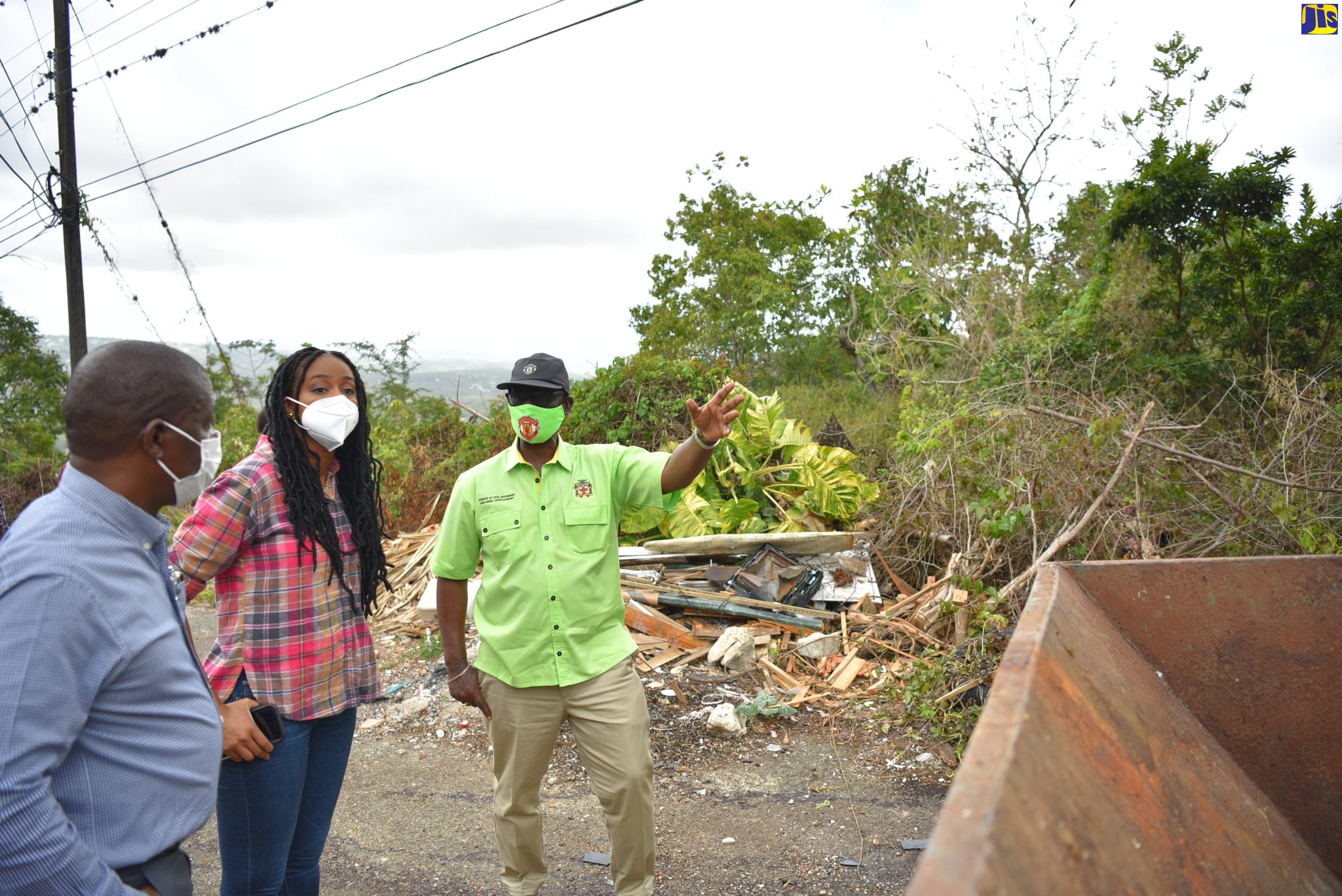 Minister of Local Government and Rural Development, Hon. Desmond McKenzie, discusses measures to address garbage pile-up along the Bellefield Hill Main Road in Manchester with Mayor of Mandeville, Councillor Donovan Mitchell, and Member of Parliament for Manchester Central, Rhoda Moy Crawford, during a tour of the constituency on Thursday (March 24).