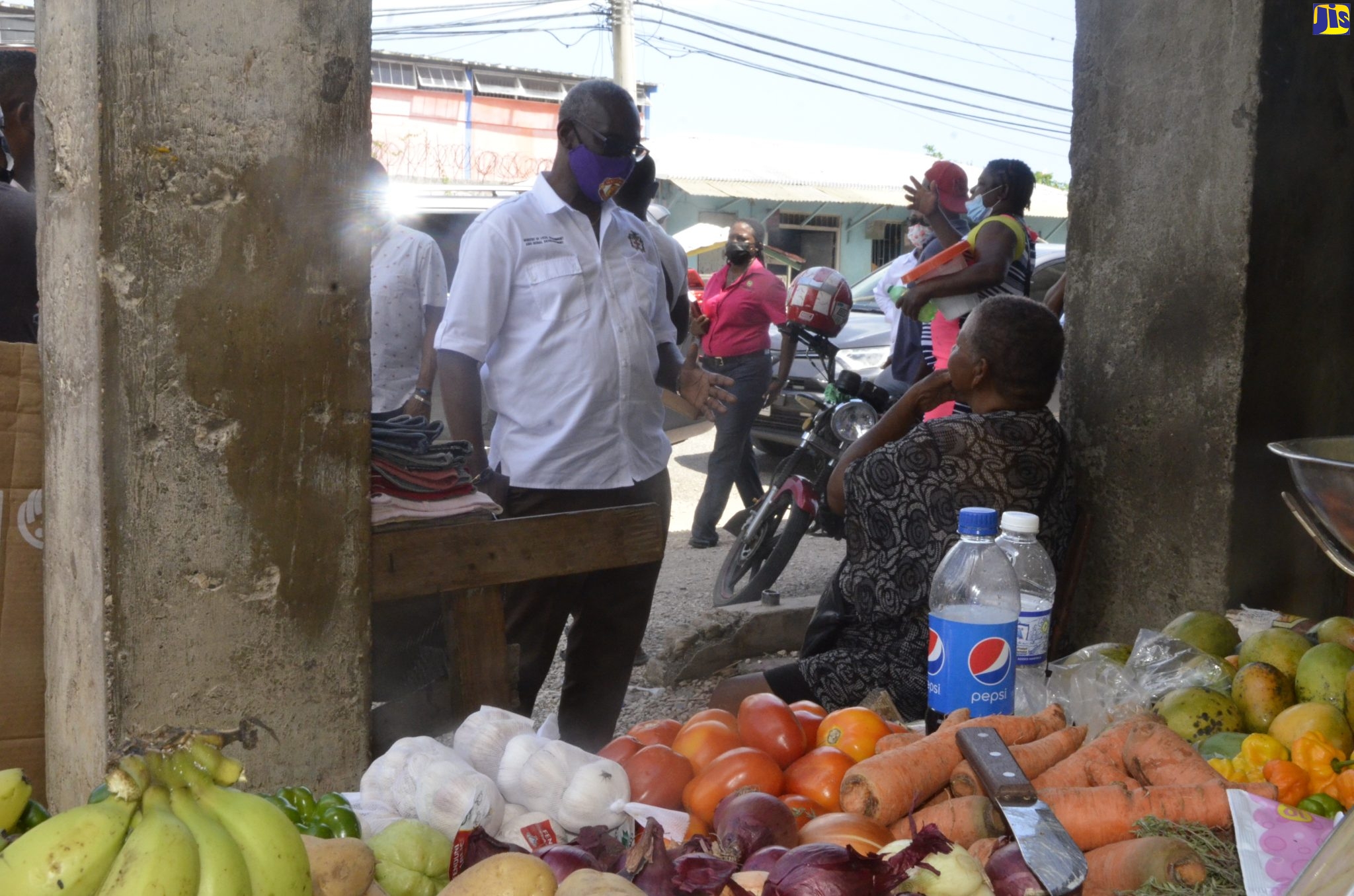 Minister of Local Government and Rural Development, Hon. Desmond McKenzie, interacts with vendor, Atrene Walker, during a tour of the Little London Market in Westmoreland on Thursday, April 7.