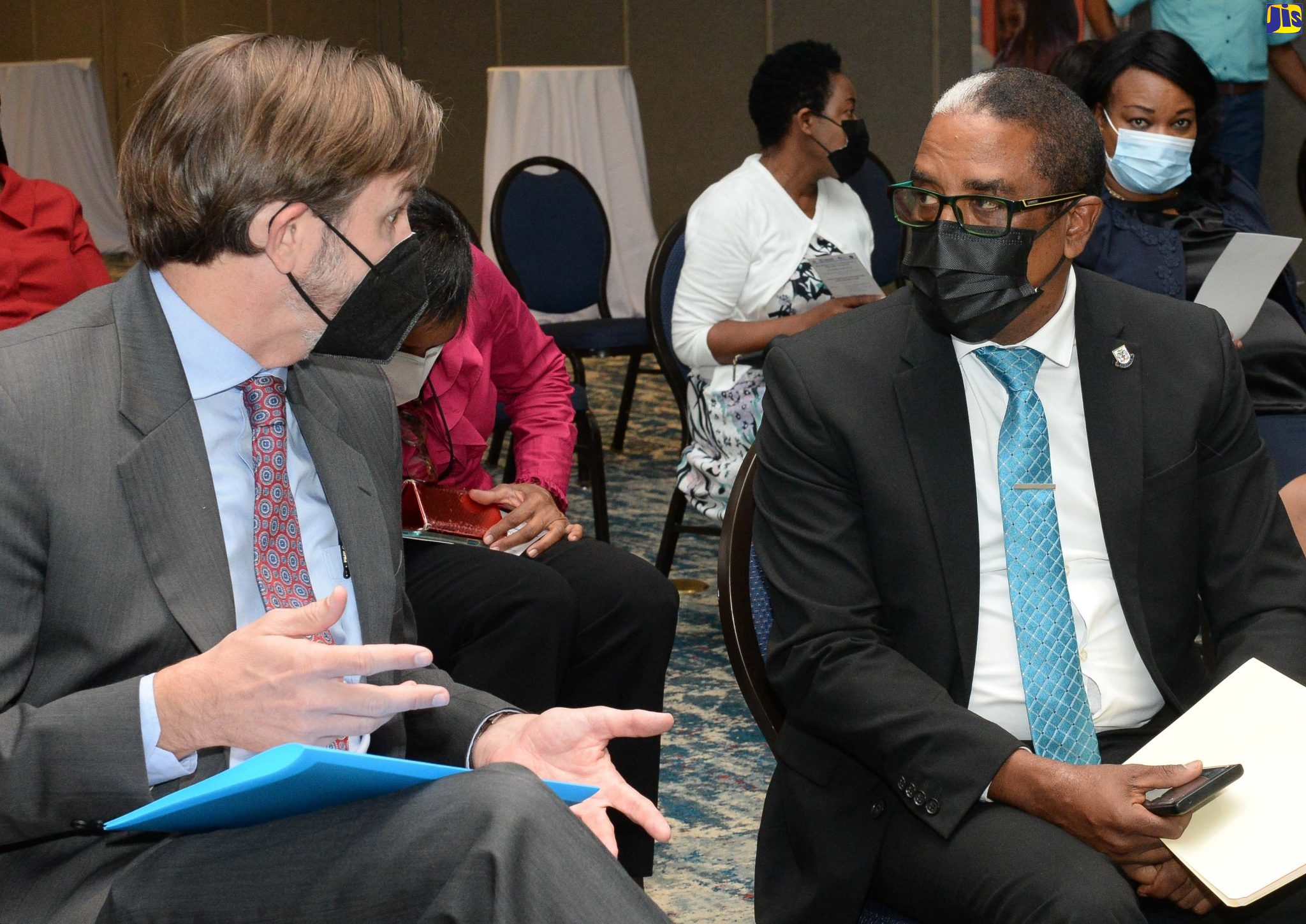 Minister of State in the Ministry of Industry, Investment and Commerce, Dr. Hon. Norman Dunn, conversing with Country Representative (Ag), USAID Jamaica Alex Gainer, during the official launch of the Department of Co-operatives and Friendly Societies’ Online Registration and Monitoring System (ORMS) at The Jamaica Pegasus hotel in New Kingston on Thursday (April 14).