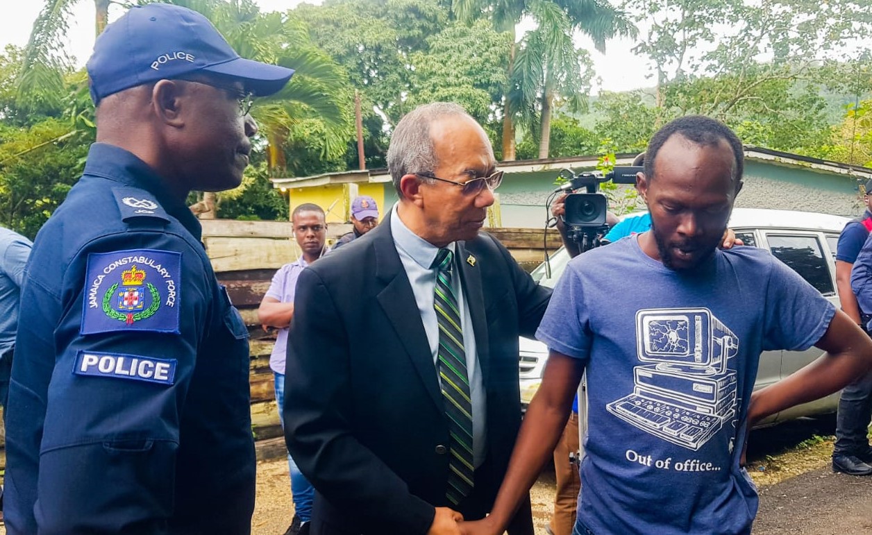 Minister of National Security , Hon. Dr. Horace Chang (centre), comforts Kamoill Williams Sr.  (right),  the grieving father of three-year-old Kamoill Williams Jr., of Cascade in Hanover. Occasion was a visit by the Minister to the families of Kamoill and 27-year-old Tavares Stevens, on Saturday (April 23). Both were slain in a drive-by shooting incident on April 20. Looking on is Head of the Area One Police, Assistant Commissioner of Police (ACP) Clifford Chambers. 