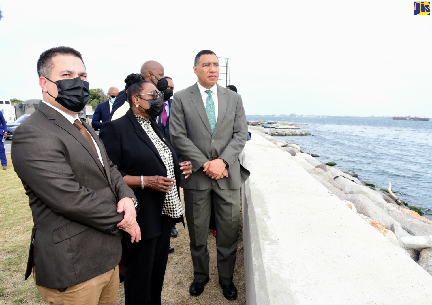 Prime Minister, the Most Hon. Andrew Holness (right), admires the work done under the $1.3-billion Port Royal Street Coastal Revetment Project during a tour of the corridor following a ceremony to officially hand over the project to the Kingston and St. Andrew Municipal Corporation (KSAMC) on Wednesday (May 18).  The project comprises the installation of a one-kilometre composite seawall and armour stone revetment structure, upgrading of drainage features, rehabilitation and raising of the existing roadway along the corridor, installation of a boardwalk , and the creation of a fishing beach. Also pictured (from left) are Minister without Portfolio in the Ministry of Economic Growth and Job Creation, Senator the Hon. Matthew Samuda; and Minister of Culture, Gender, Entertainment and Sport, Hon. Olivia Grange. The handover ceremony was held at the Breezy Castle Sports Centre in downtown Kingston.