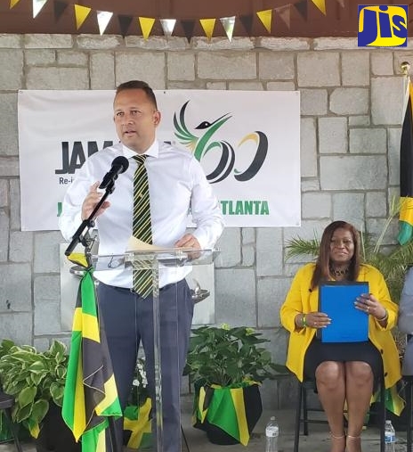 Jamaica’s Consul-General in Miami, Oliver Mair, delivering the message from Minister of Culture, Gender, Entertainment and Sport, Hon. Olivia Grange, at the Atlanta launch of Jamaica-60 celebration activities. Seated is Jamaica’s honorary consul in Atlanta, Dr. Elaine Bryan.

