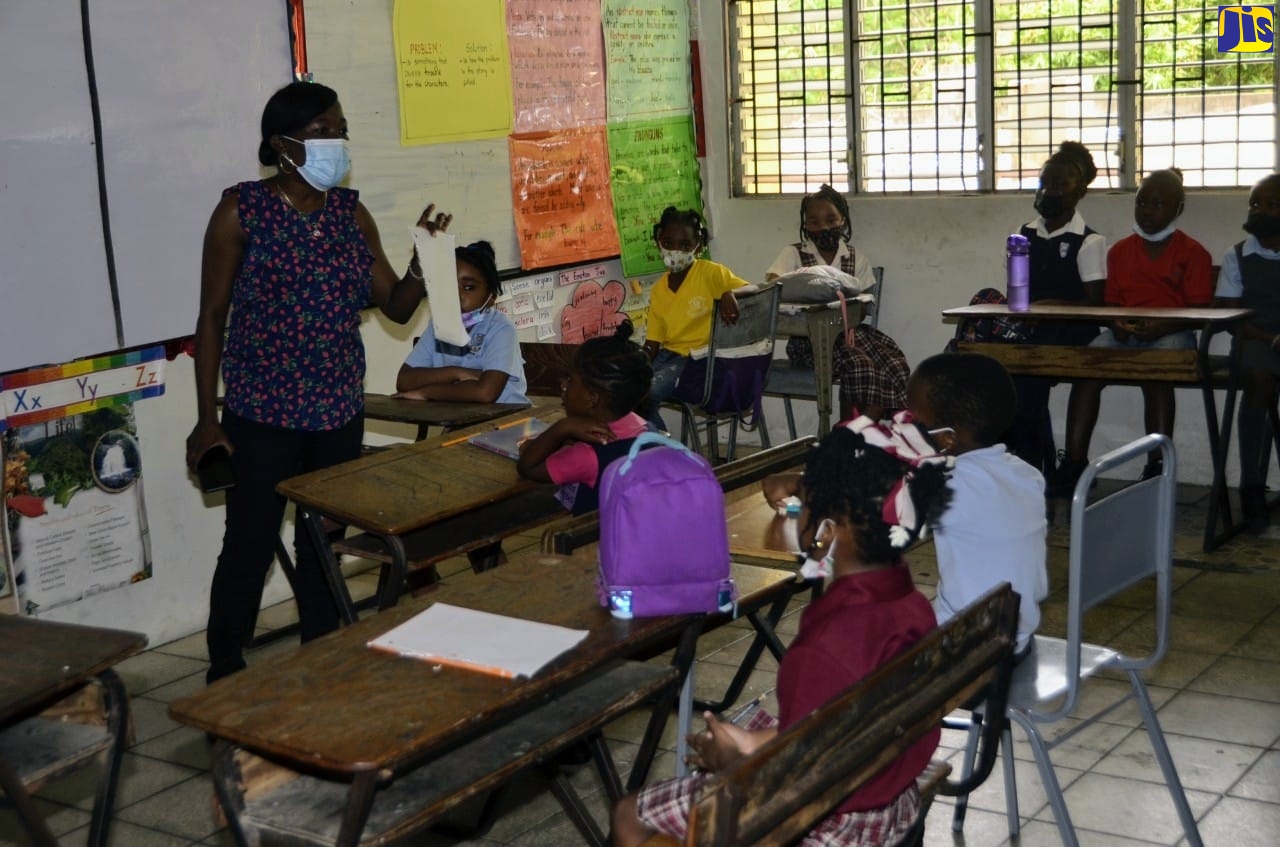 Teacher of Middlesex Corner Primary School in Hanover, Therene Chambers, outlining the rules of the literacy game, Time-O-Rhyme, to students during the Region four  Literacy Fair 2022, at the Flanker Primary School in St. James, on Thursday (May 19).