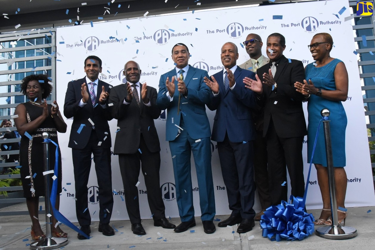 Prime Minister, the Most Hon. Andrew Holness  (fourth left), applauds after cutting the ribbon to symbolise the commissioning of new state-of-the-art business process outsourcing (BPO) office spaces built at the Portmore Informatics Park, during a ceremony at the facility in St. Catherine, on Thursday (May 5).  Also applauding (from left) are Vice President, BPO and Logistics, Port Authority of Jamaica (PAJ), Gloria Henry; Chairman of the PAJ, Alok Jain; Minister of Industry, Investment and Commerce, Senator the Hon. Aubyn Hill; President and Chief Executive Officer (CEO) of the PAJ, Professor Gordon Shirley; Chairman, Kingston Free Zone Company Limited, Lyttleton Shirley; Member of Parliament for St. Catherine South Eastern, Robert Miller, and Senior Vice President for Finance, Information Technology, Corporate Strategy and Procurement, PAJ, Elva Williams Richards. 