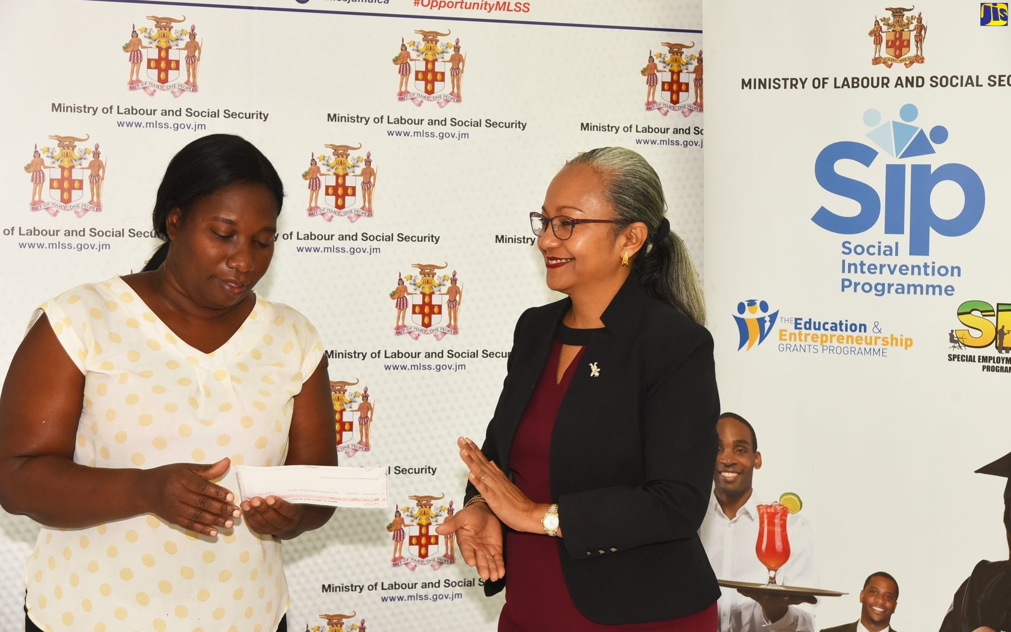 Permanent Secretary in the Ministry of Labour and Social Security, Colette Roberts Risden (right), presents a cheque to Michele Clarke. Occasion was a ceremony for the handover of entrepreneurship grants to female domestic workers at the Ministry’s office in Kingston on Wednesday (May 4).