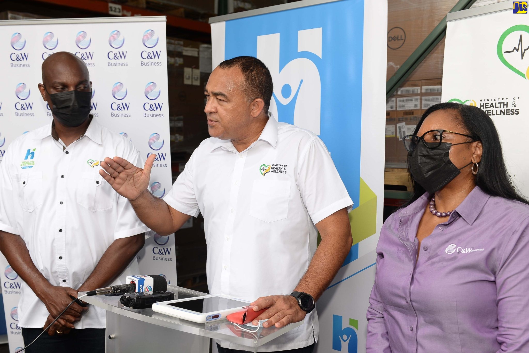 Minister of Health and Wellness, Dr. the Hon. Christopher Tufton (centre), provides details of the data centre being established to link patients’ information from all public health centres and hospitals to one central network. Joining him are (from left) the Ministry’s Information System 4 Health (IS4H), Information and Communications Technology (ICT) Lead, Shawn Bolton; and Director, Government Enterprise and Information Technology Solutions, at Cable and Wireless Communications (C&W), Carol Robertson. The Minister participated in a tour of the e-Gov Jamaica Limited Data Centre and the C&W Warehouse, which stores the equipment to be used for the project,  on May 12.