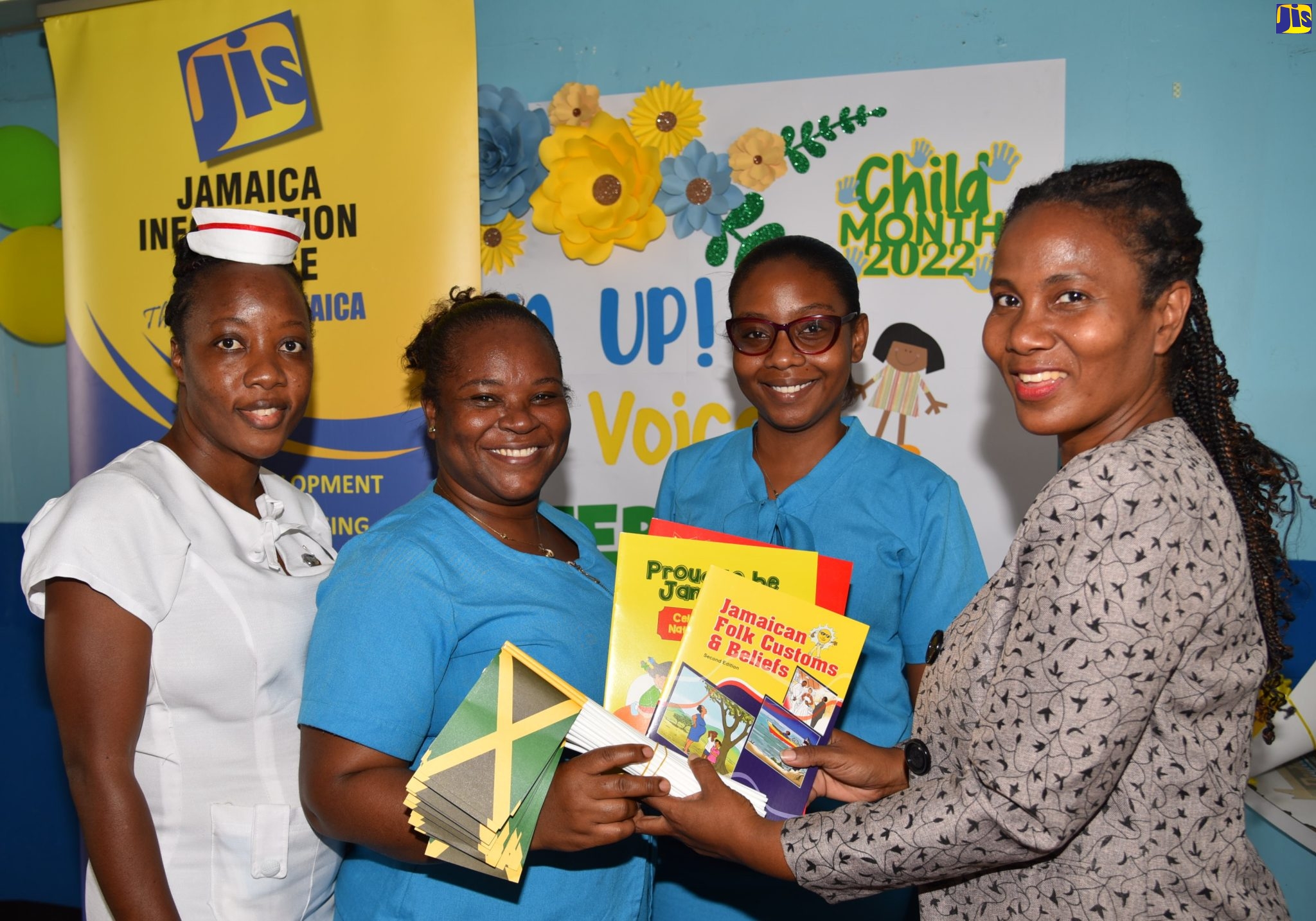 Jamaica Information Service (JIS) Special Projects Manager, Andrine Davidson (right), presents JIS publications to Community Health Aide (CHA) Sasha Stewart (second left), at the Comprehensive Health Centre on Slipe Pen Road, Kingston, on Wednesday (May 18). Also sharing in the handover are Nurse Andrea Neil-Walker (left) and CHA,Yonique Malcolm. The publications will support a treat to be hosted by the clinic for up to 300 children from the surrounding communities as part of activities for Child Month under the theme ‘Listen Up! Our Children’s Voices Matter’.
