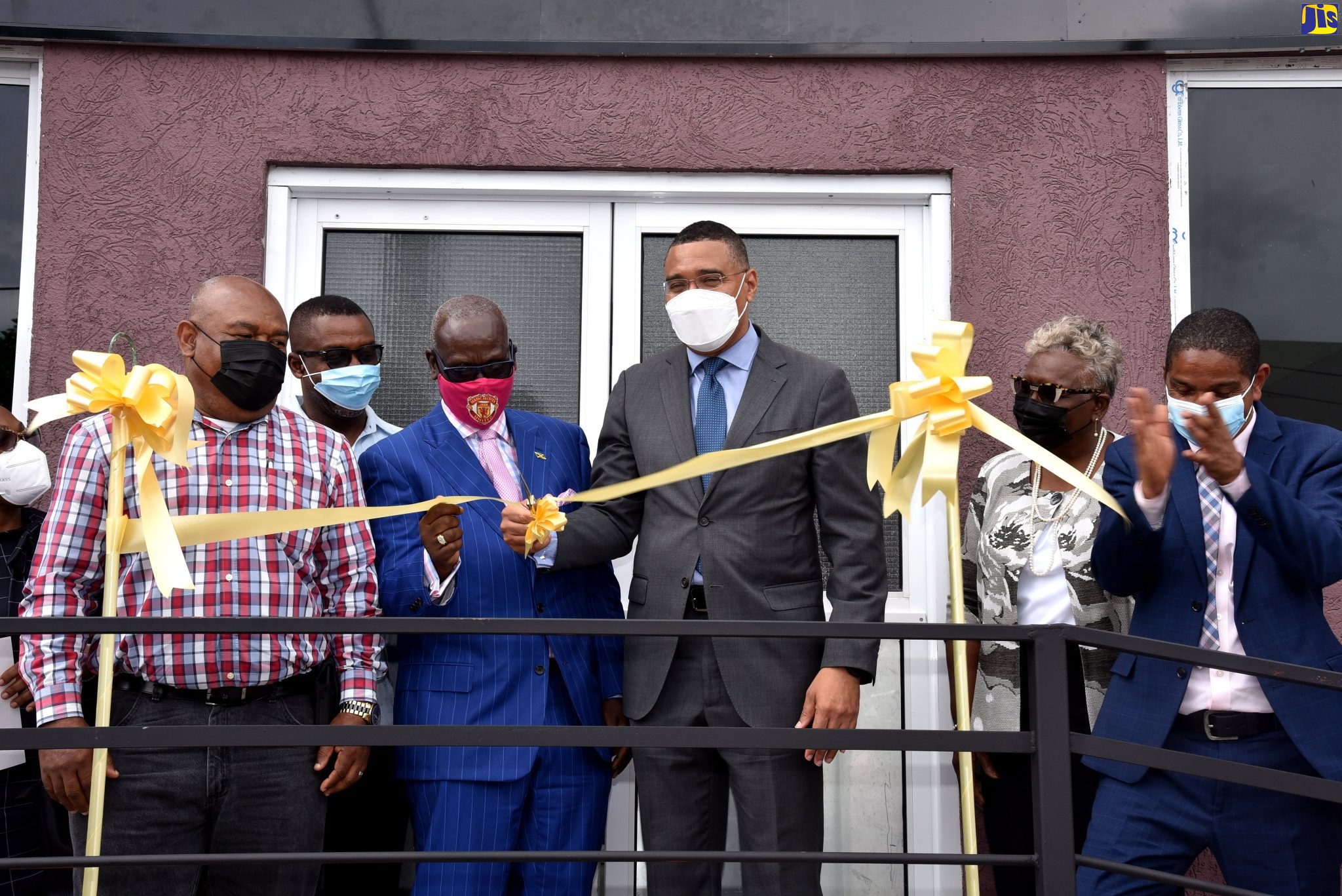 Prime Minister, the Most Hon. Andrew Holness (third right), cuts the ribbon to officially open the $140 million Desmond McKenzie Transitional Centre for the Homeless in downtown Kingston, on Friday (May 28). Assisting him is Minister of Local Government and Rural Development, Hon. Desmond McKenzie (second left), while Mayor of Kingston, Senator Councillor Delroy Williams (right), applauds. Others (from left) are Deputy Mayor of Kingston, Councillor Winston Ennis, Minority Leader, Kingston and St. Andrew Municipal Corporation (KSAMC), Councillor Andrew Swaby, and Minister McKenzie’s wife, Marcia McKenzie.