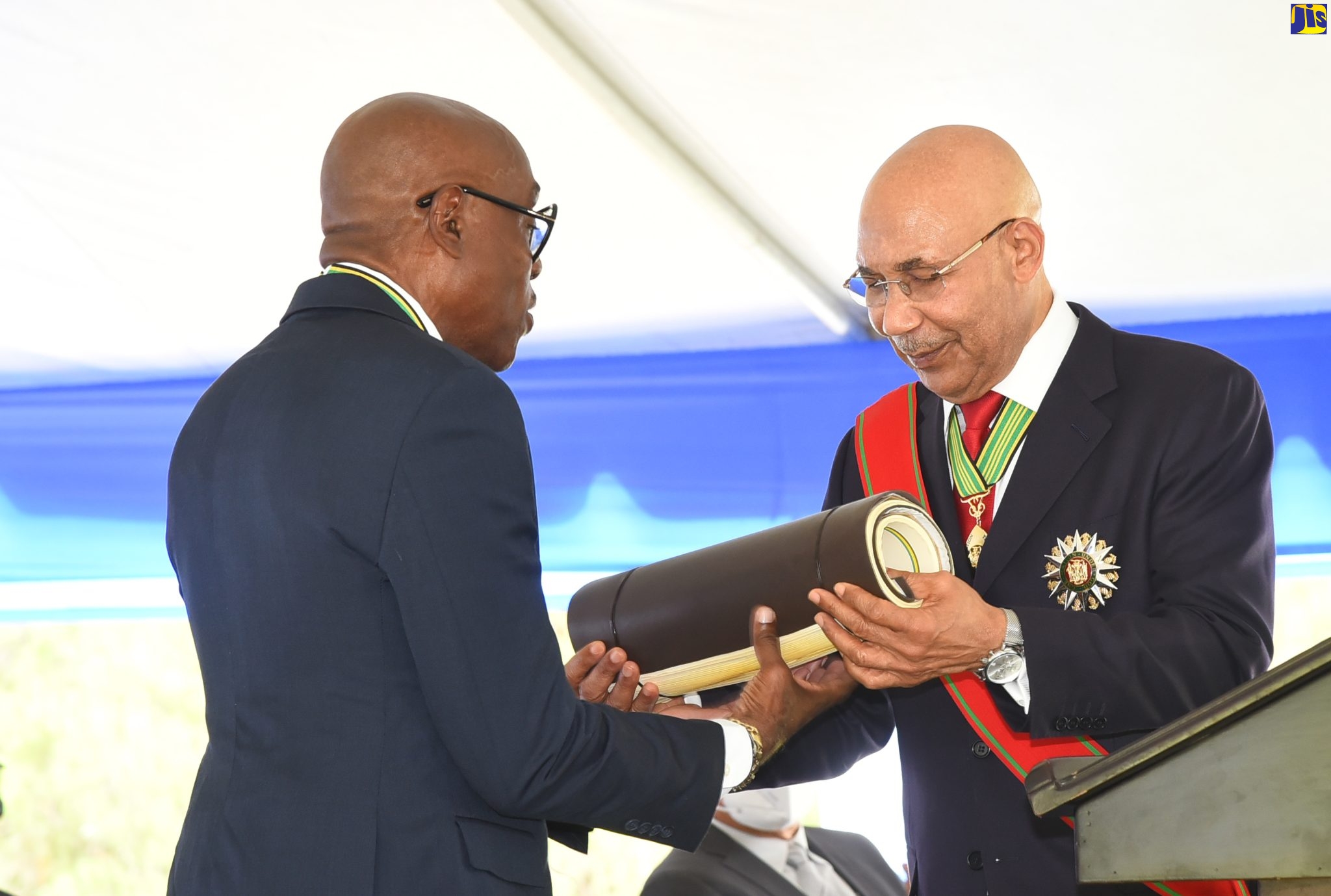 Governor-General His Excellency the Most Hon. Sir Patrick Allen (right), presents newly installed Custos Rotulorum for St. Andrew Hon. Ian Forbes with the Magistrates’ Roll for the parish, during his installation ceremony . The event was held at the Hope Royal Botanical Gardens in the parish on Thursday (May 12).  