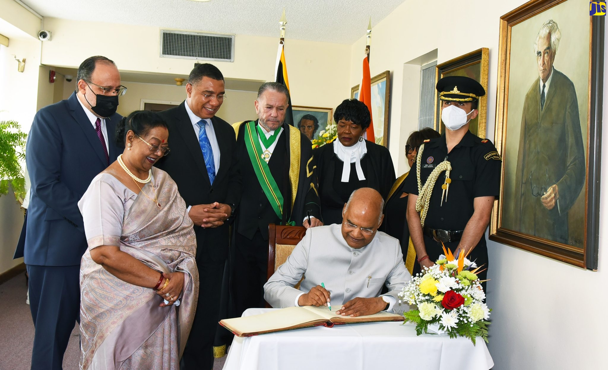 President of the Republic of India, His Excellency, the Hon. Ram Nath Kovind (seated) signs the guest book after addressing a joint sitting of the Houses of Parliament on Tuesday (May 17), which was held as part of activities during his four-day State visit to Jamaica. Looking on (from left) are First Lady of India, Savita Kovind; Leader of the Opposition, Mark Golding; Prime Minister the Most Hon. Andrew Holness; President of the Senate, Senator Thomas Tavares-Finson; Clerk to the Houses of Parliament, Valerie Curtis; and Speaker of the House of Representatives, Marisa Dalrymple-Philibert.