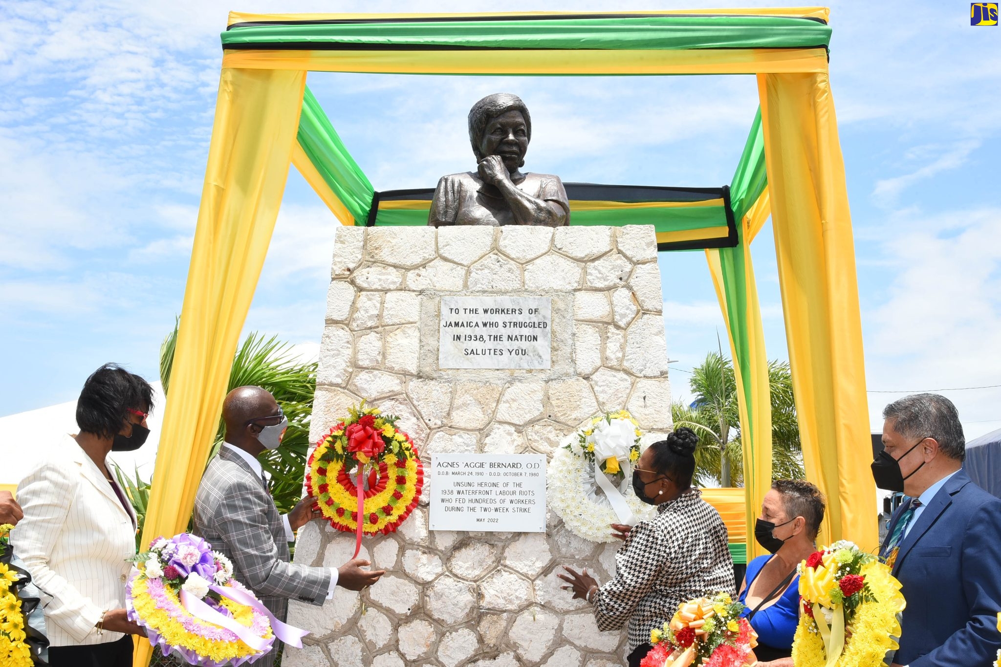 Minister of Local Government and Rural Development, Hon. Desmond McKenzie (second left) and Minister of Culture, Gender, Entertainment and Sport, Hon. Olivia Grange (third right), place wreaths at the Aggie Bernard monument, Kingston Craft Market, downtown Kingston, on May 18, in recognition of National Workers Week/Labour Day. Others looking on are (from left), Chief Technical Director, Ministry of Labour and Social Security, Dione Jennings; Goddaughter of Agnes Bernard, Cordelia Forbes; and President of the Jamaica Employers’ Federation, David Wan. A bust, mounted atop the monument, was unveiled at the event.