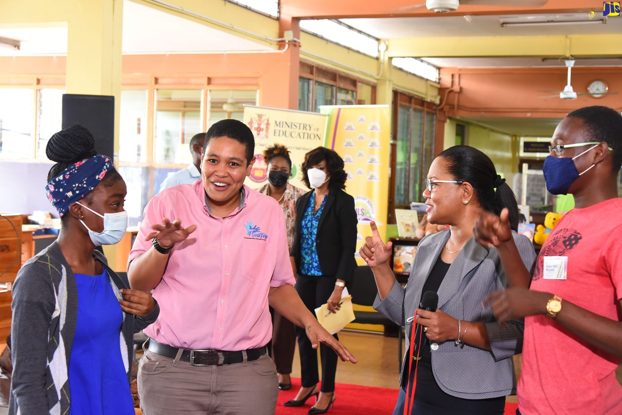Education Officer, Special Education Unit at the Ministry of Education and Youth,  Christina Addington (second right), and sign language interpreter, Antoinette Aiken (second left), engages with children from the deaf community (from left) McKayla Fitzgerald and Adien- Neil McLead during the Children’s Day Forum hosted by the Ministry at the Kingston and St. Andrew Library recently.