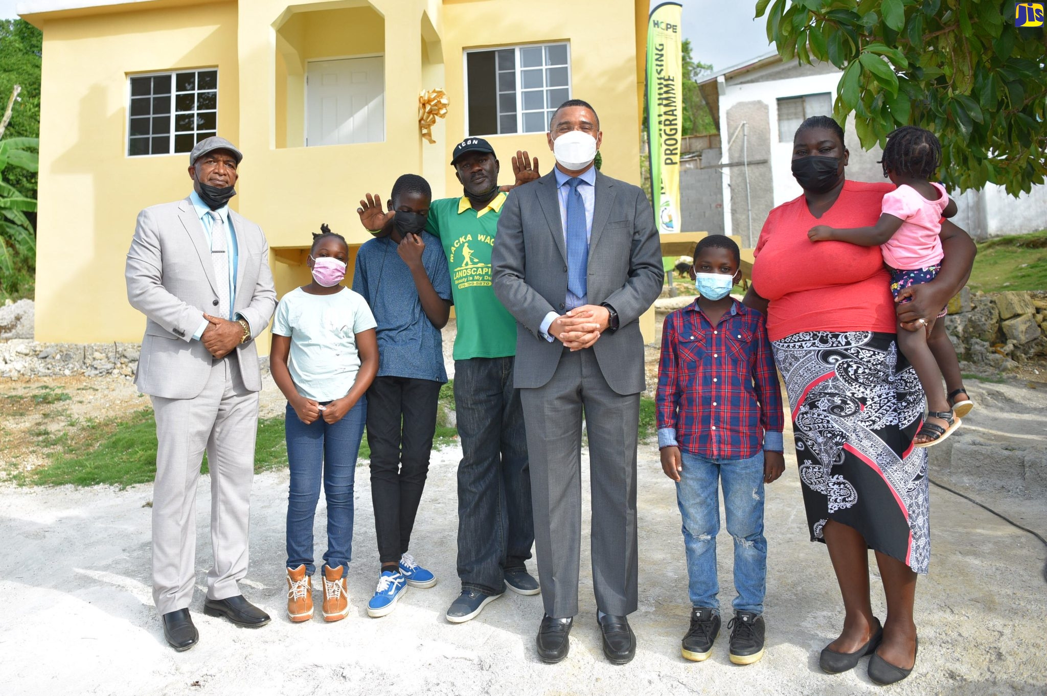 Prime Minister, the Most Hon. Andrew Holness (fourth right), and Member of Parliament for St. Elizabeth North Eastern, Delroy Slowley (left), share a moment with Courtney (fourth left) and Topal Williams (second right) and their children, at the handover of a new three-bedroom unit to the family at Schoolfield in Santa Cruz, St. Elizabeth, recently. The house was provided under the New Social Housing Programme (NSHP).