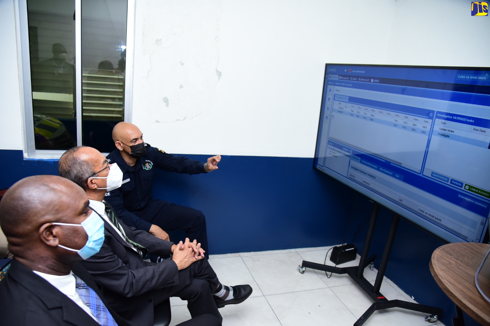 Minister of National Security and Deputy Prime Minister, Hon. Dr. Horace Chang (second left), listens as Commissioner of Police, Major General Antony Anderson (right), explains a key aspect of the Station Records Management System being implemented within the Jamaica Constabulary Force (JCF), during a live demonstration of how the system works, at the Harbour View Police Station in the Kingston Eastern Division, on Thursday (June 9). Also pictured is State Minister in the National Security Ministry, Hon. Zavia Mayne. The system will facilitate electronic recording of reports, complaints, and administrative entries by the police. It was introduced at the Harbour View Police Station in April and is the first of the 24 stations targeted to benefit under the initial phase of the project.