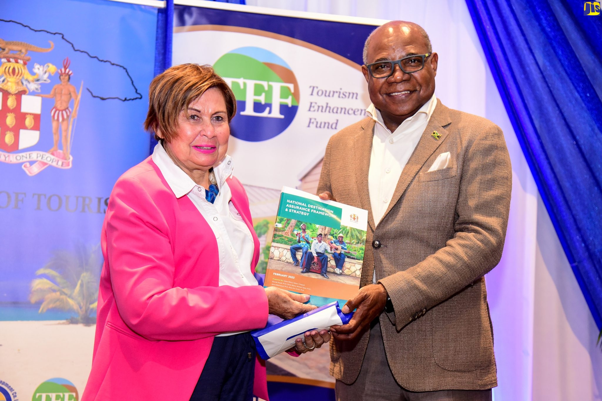 Tourism Minister, Hon. Edmund Bartlett (right), presents a copy of the National Destination Assurance Framework and Strategy to Association of Jamaican Attractions Limited President, Marilyn Burrowes, on Friday (June 10). The document was one of several disaster risk management tools presented to industry stakeholders during a ceremony at the Jamaica Pegasus Hotel in New Kingston.
