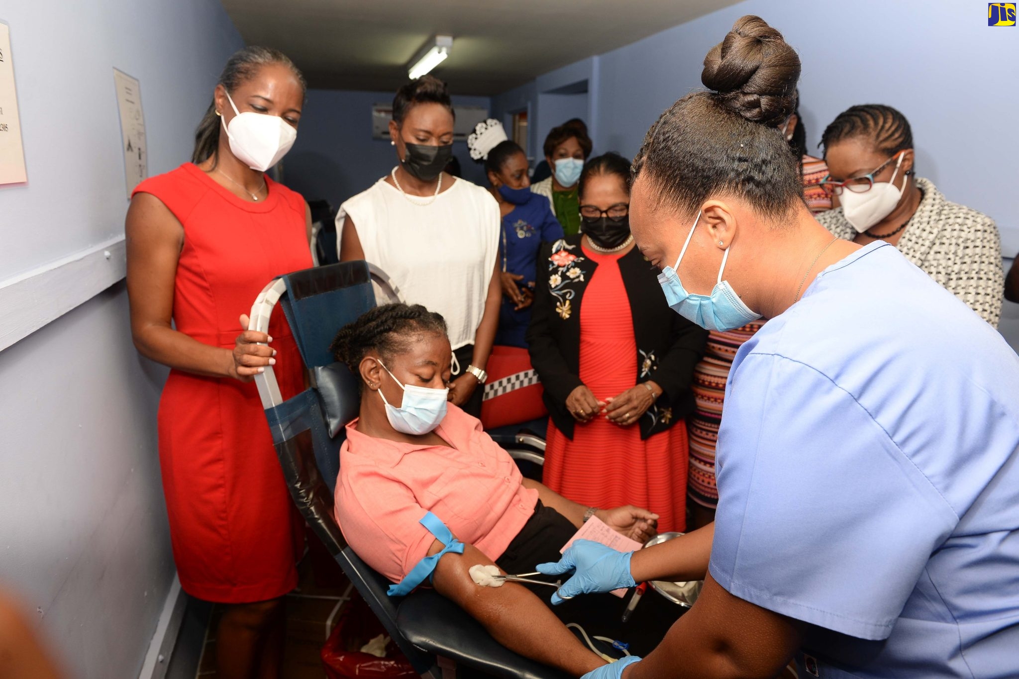 Minister of State in the Ministry of Health and Wellness, Hon. Juliet Cuthbert-Flynn (second left), observes as Nurse Danika Harriot (right) collects blood from Kadian Stewart (in chair),  at the official opening of a Blood Collection Centre, at the Spanish Town Hospital in St. Catherine today (June 14). Also observing are (from left) Director of the National Blood Transfusion Service (NBTS), Dr. Natalie Sharpe; Custos of St. Catherine, Hon. Icylin Golding, and Chief Executive Officer, Spanish Town Hospital, Jacqueline Ellis.
