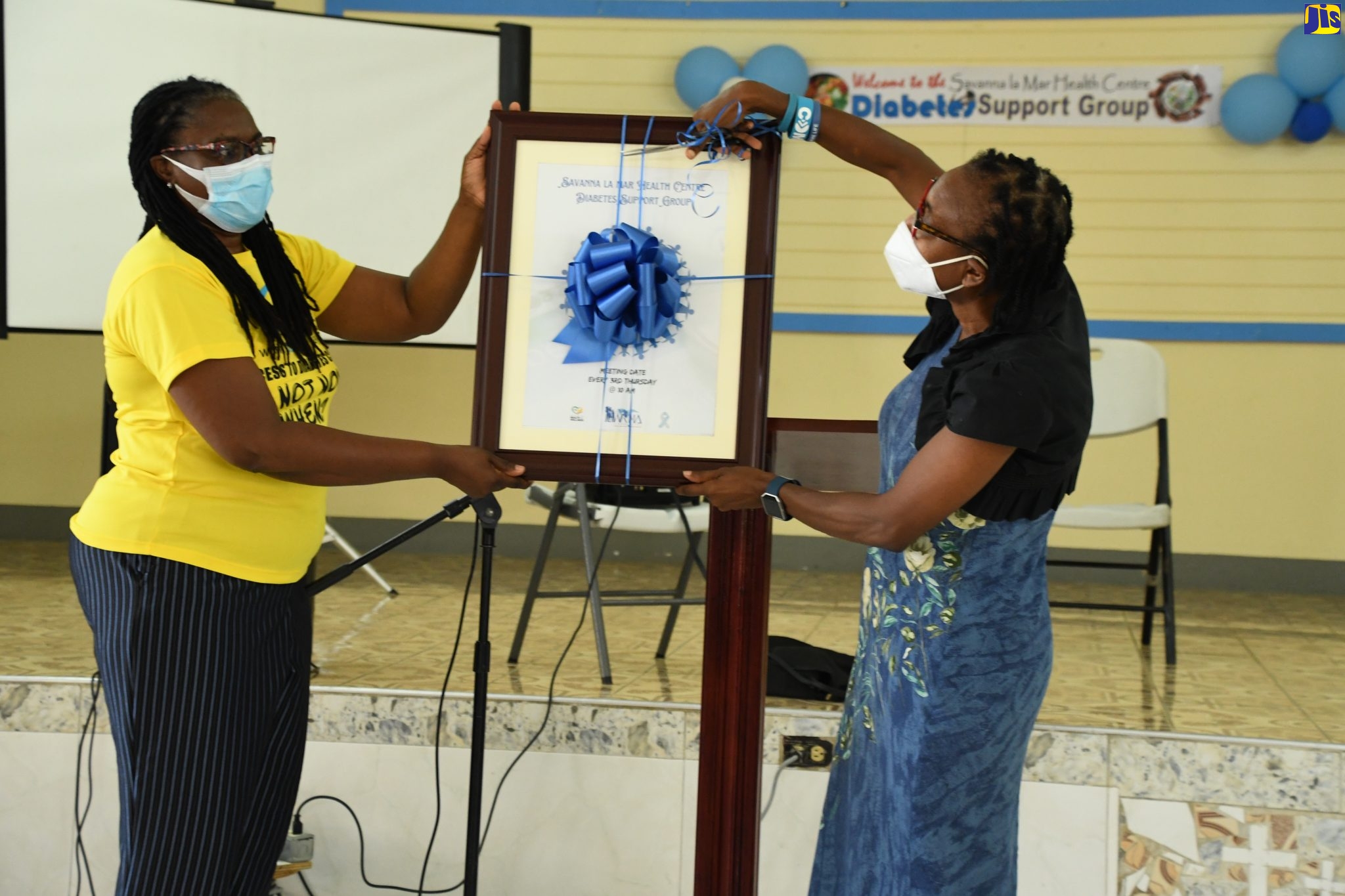 Medical Officer of Health for Westmoreland, Dr. Marcia Graham (right), cuts the ribbon on the Savanna-la- Mar Health Centre Diabetes Support Group commemorative plaque to officially declare the group launched. Sharing in the moment is Regional Non-Communicable Disease (NCD) Coordinator at the Western Regional Health Authority (WRHA), Dr. Marcia Johnson Campbell. Occasion was the official launch of the support group on  Wednesday (June 1).
